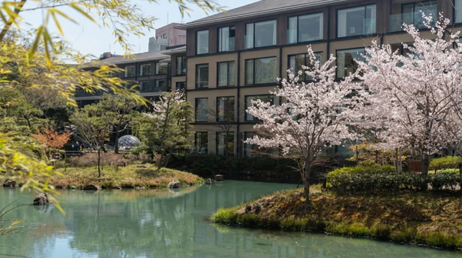 The exterior of Four Seasons Hotel Kyoto overlooking the historic Shakusuien Pond garden.