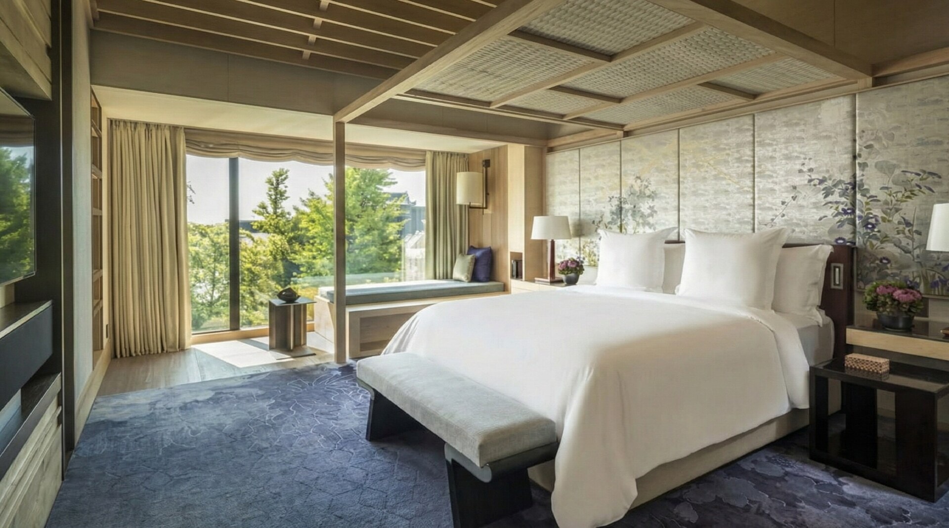 The main bedroom of the Presidential Suite with a view of the garden through floor-to-ceiling windows.