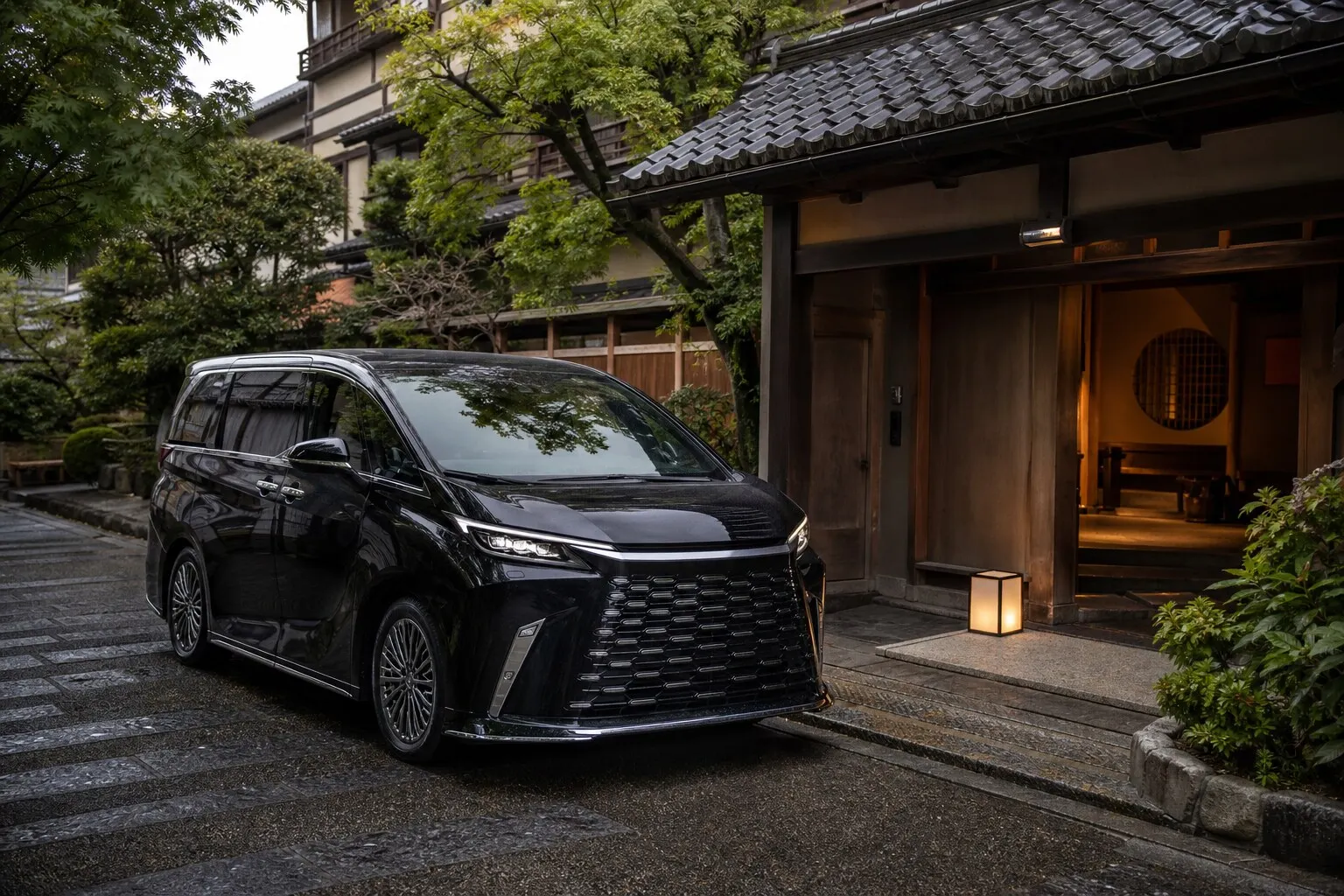A luxury black chauffeured vehicle waiting outside a traditional Japanese entrance