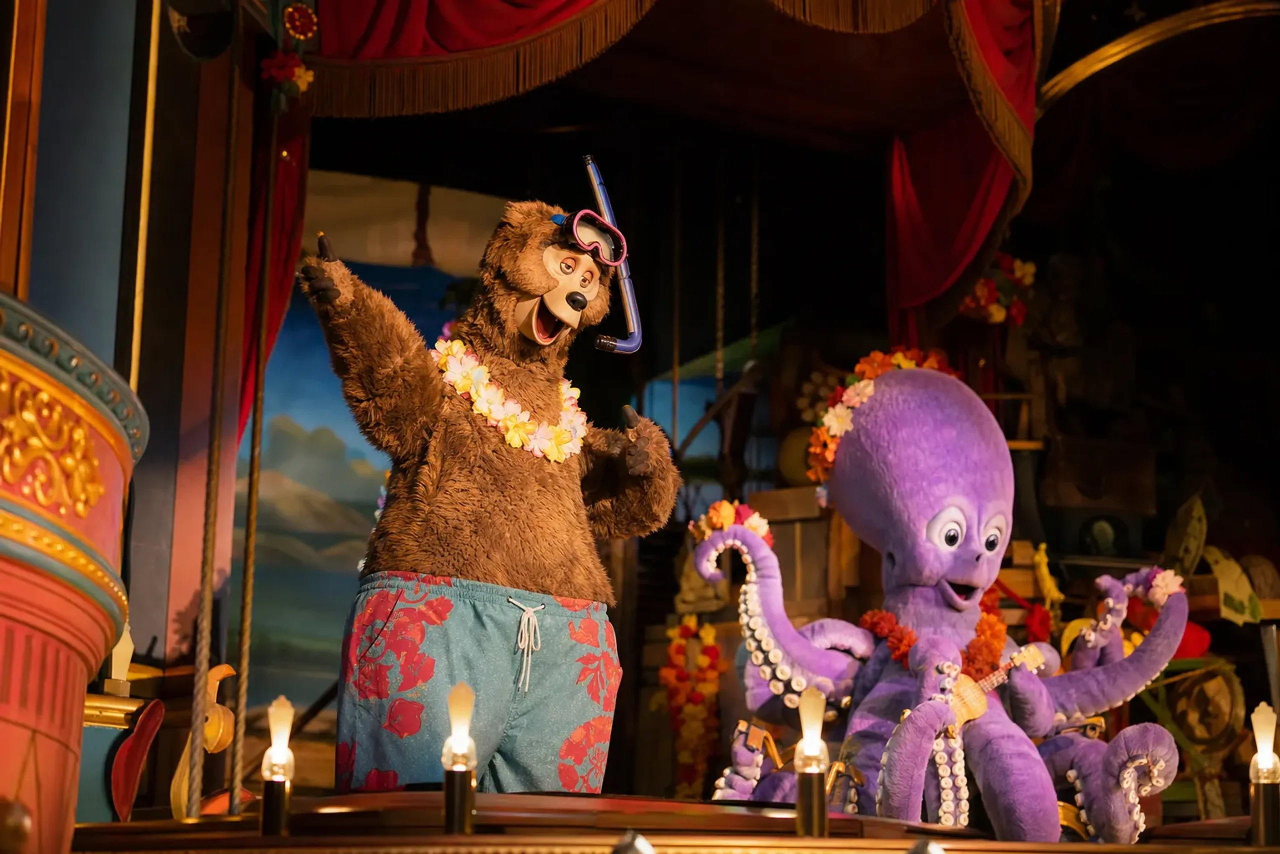 Terrance the Audio-Animatronic bear in swim trunks, goggles, and a snorkel performing beside Dolores the octopus character on the Country Bear Theater stage at Tokyo Disneyland