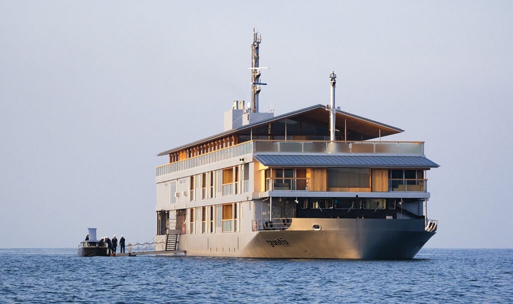 The exterior of the Guntû luxury floating hotel cruising on the calm waters of the Seto Inland Sea.