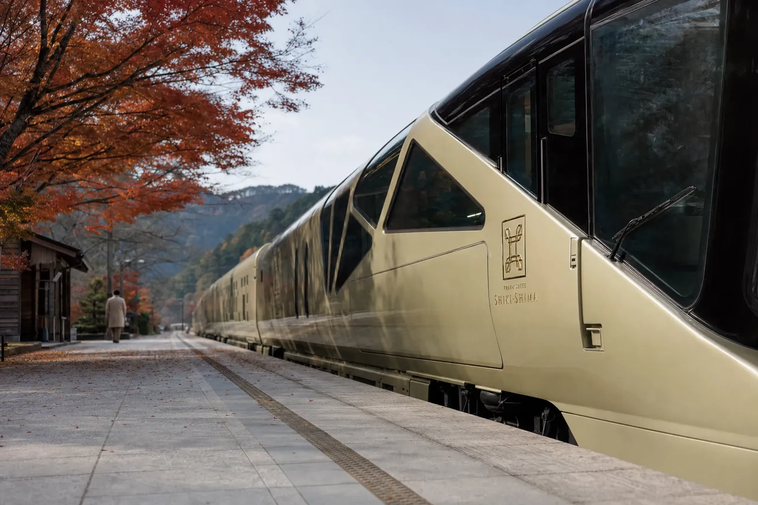 Exterior view of JR East Train Suite Shiki-shima stopped at a station platform