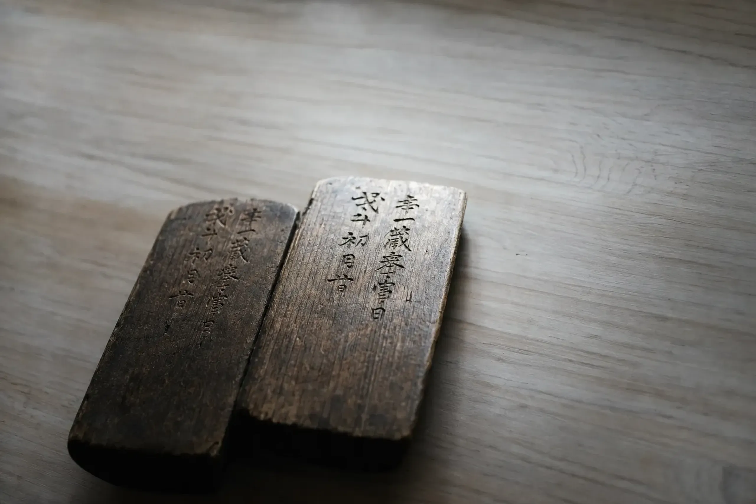 the two wooden prayer tablets from Matsue Castle, inscribed 'Keichō 16, first month, auspicious day,' resting on a wooden survey table