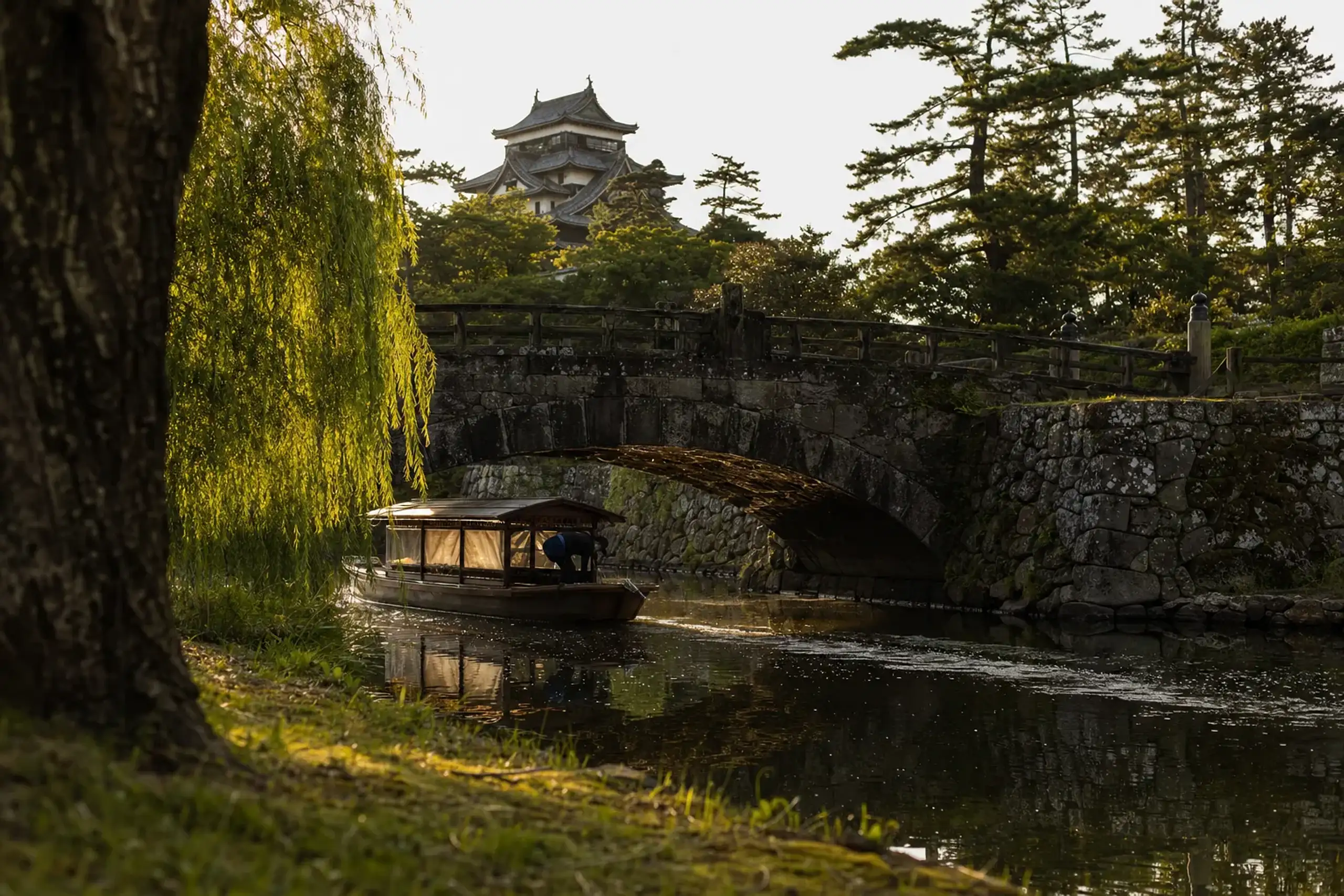 a small covered Horikawa sightseeing boat gliding along the moat and canals encircling Matsue Castle