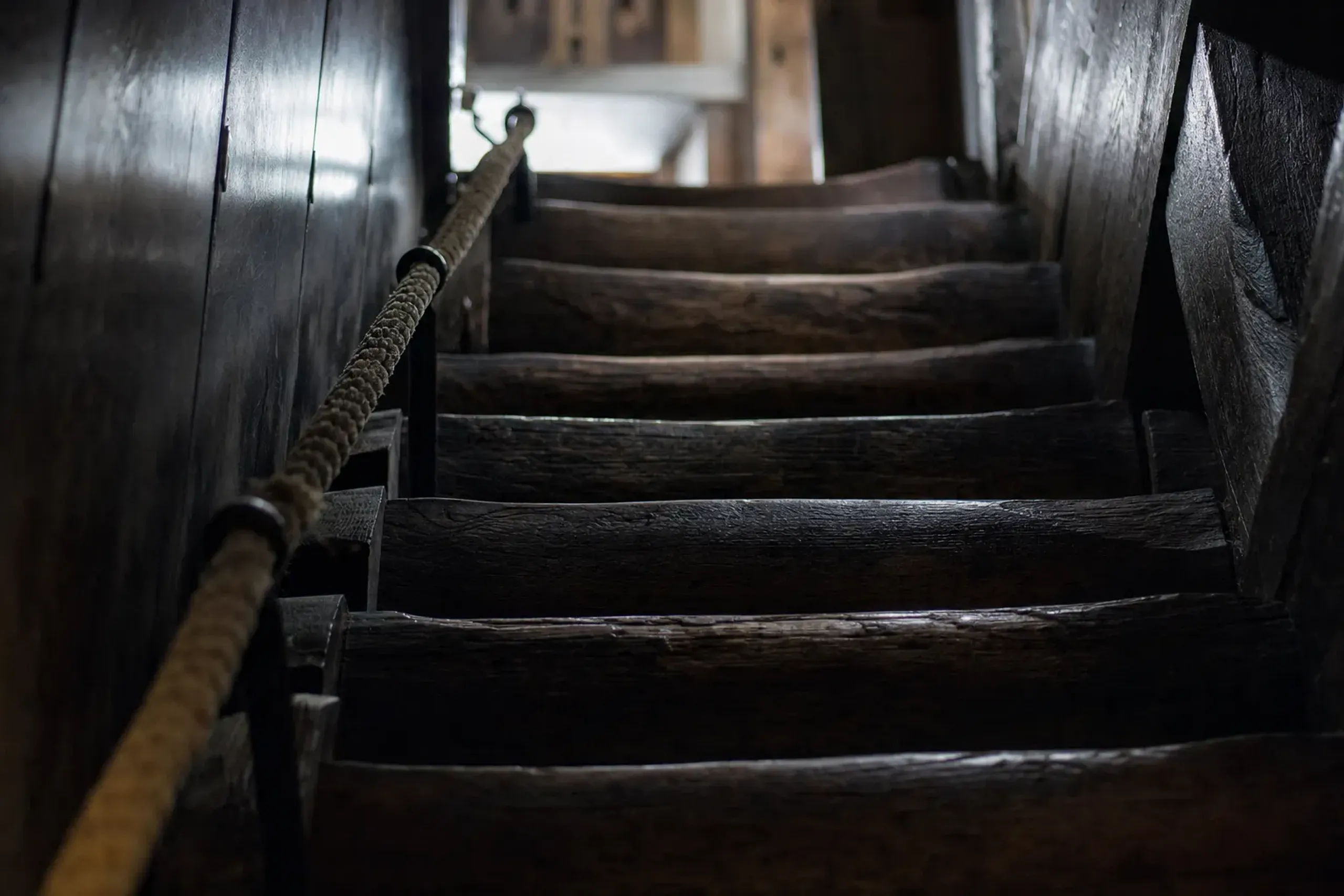 the steep original sixteenth-century wooden interior stairs of Matsumoto Castle keep, aged timber worn by centuries