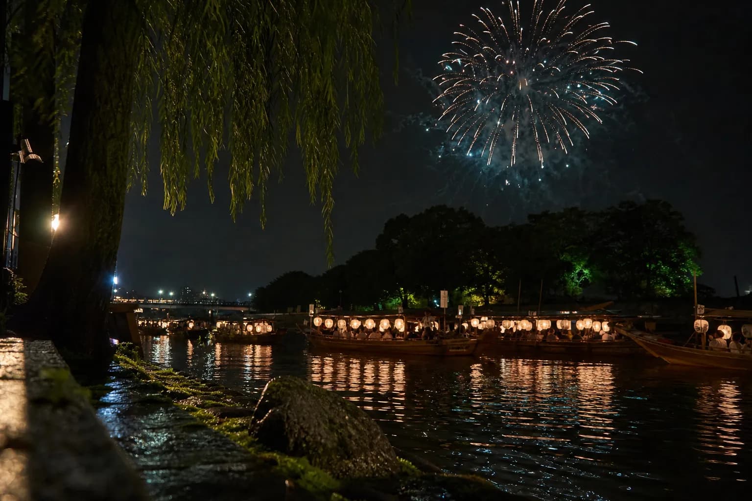 Lantern-lit boats on the Okawa river with fireworks during Osaka's Tenjin Matsuri