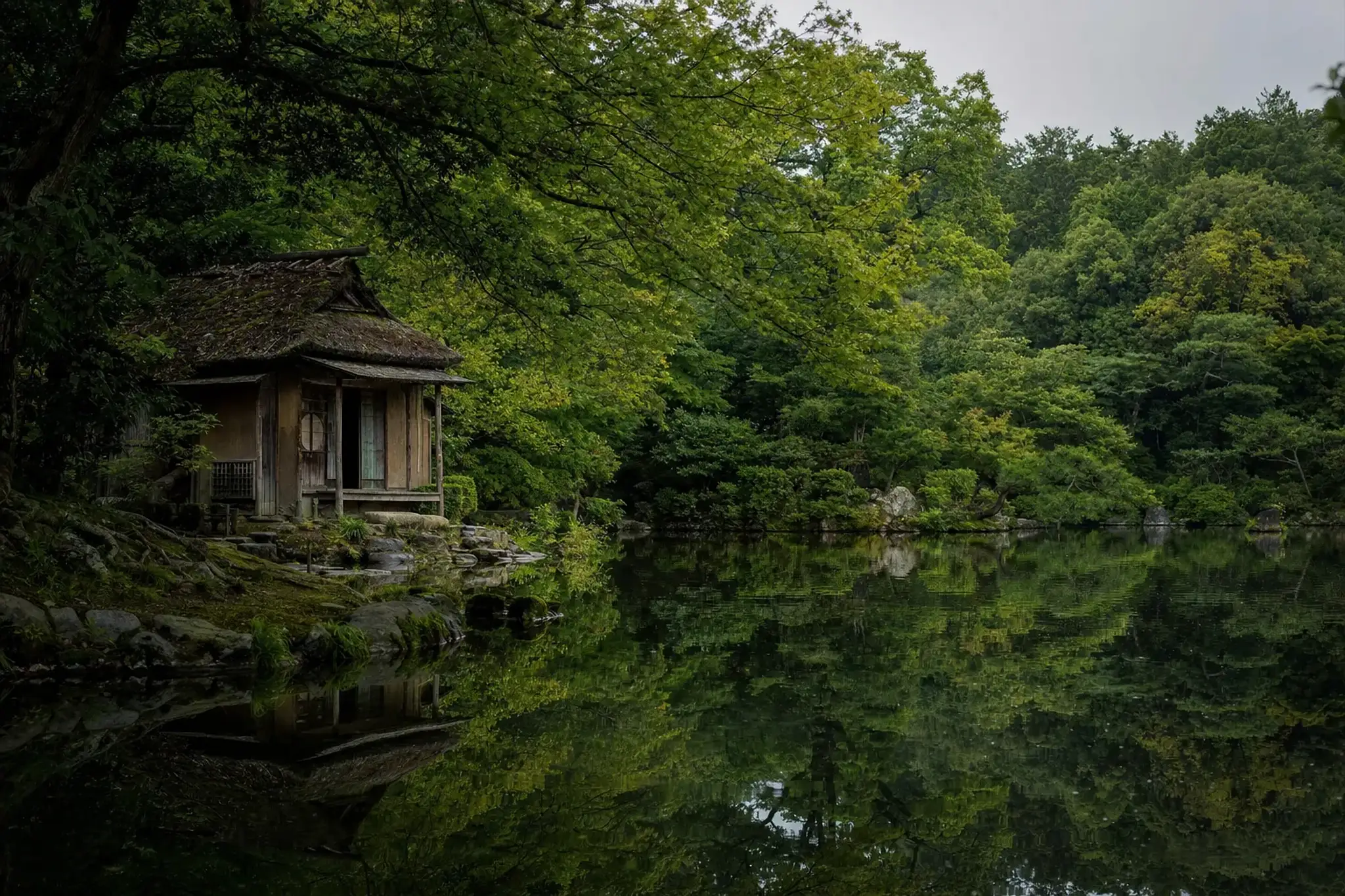 The small Hagi-no-o tea house of the original 1845 Nabeshima villa garden, set beside its modest pond near the entrance