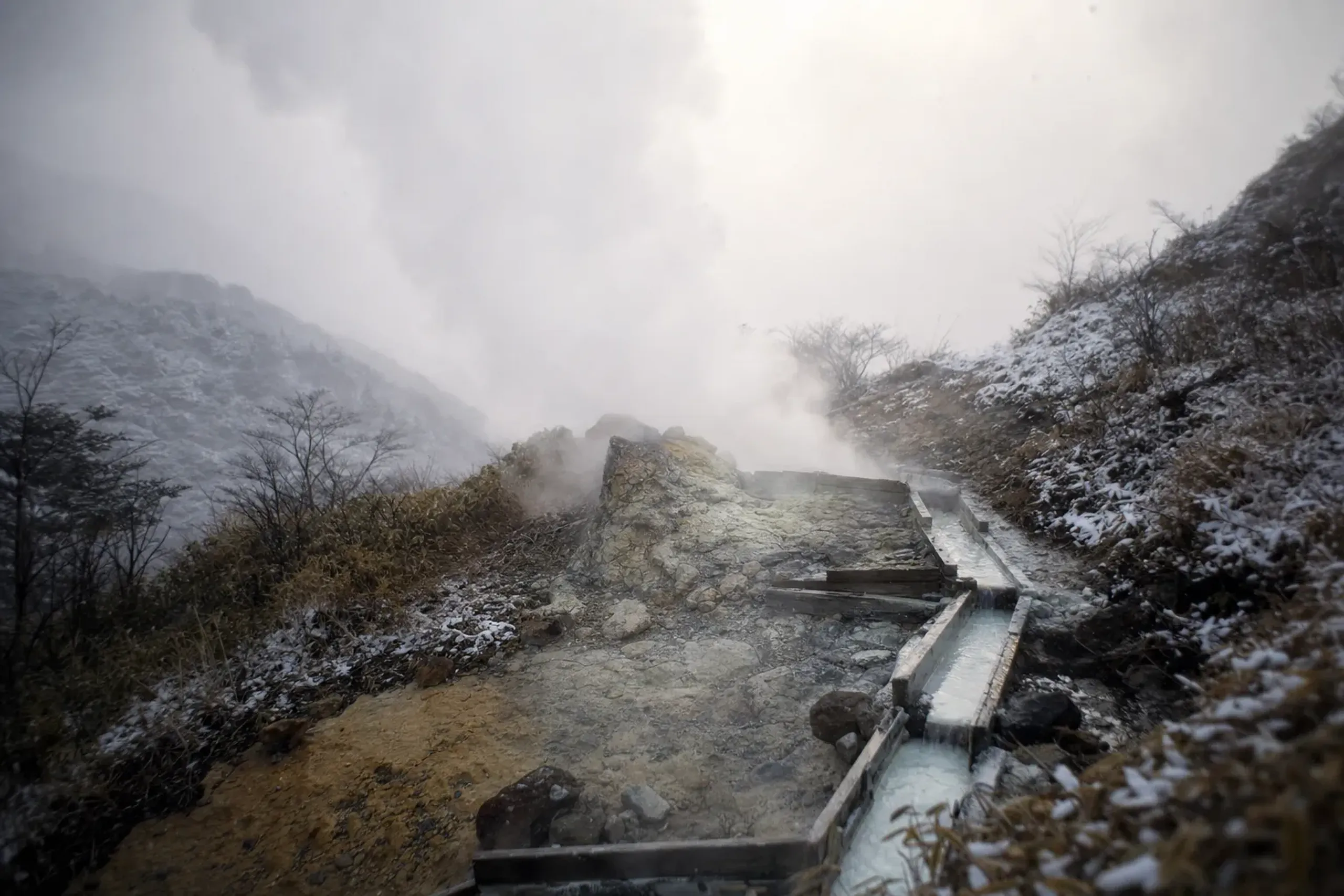 Steam hissing from the Kojigoku volcanic vent above Hakone, with a rough hot-spring water channel descending the mountainside