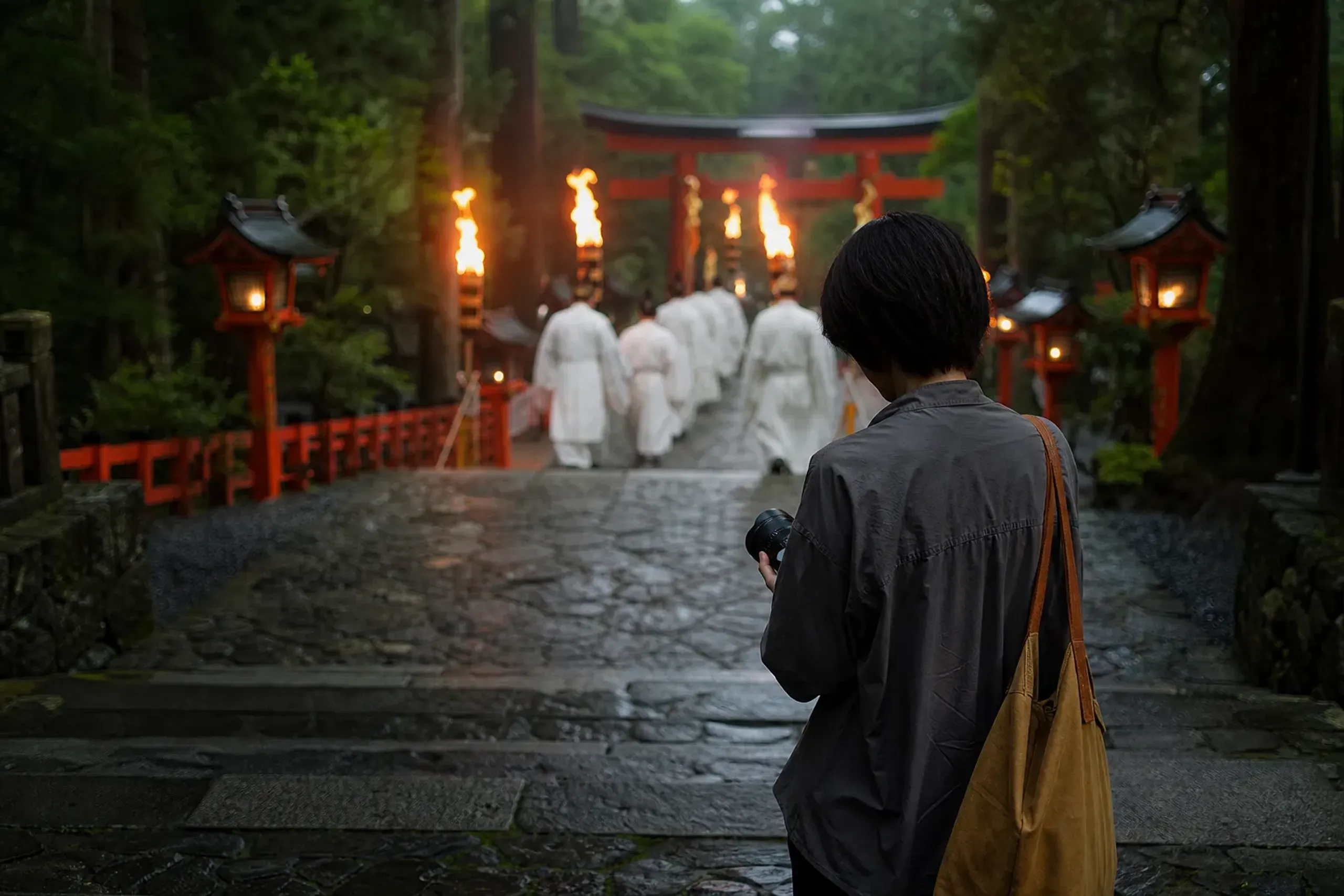 A visitor holding a camera low and discreetly while observing a sacred festival procession in Japan