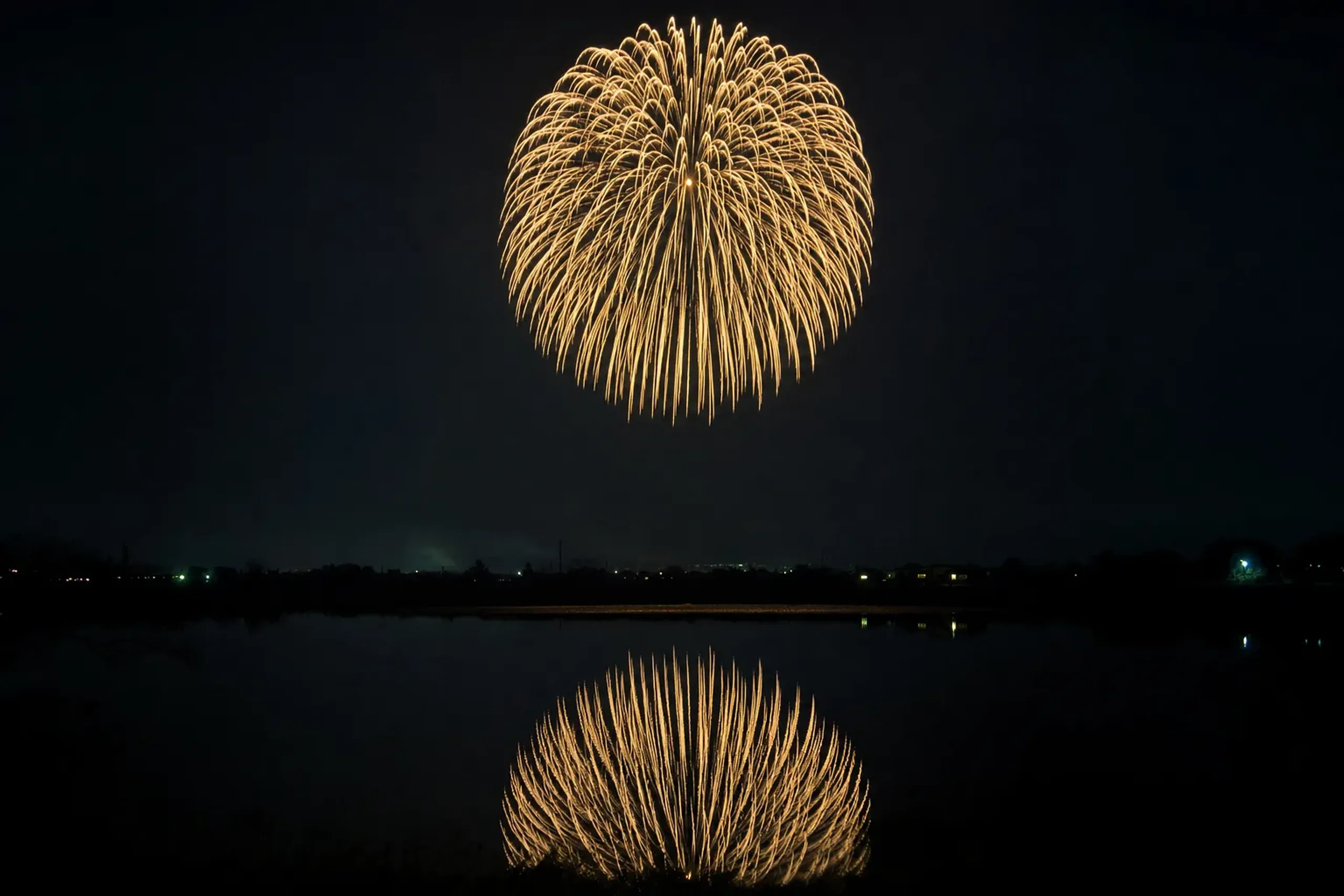 the massive sanjaku shell bursting into a 650-metre bloom high above the Shinano River, its light reflected across the water
