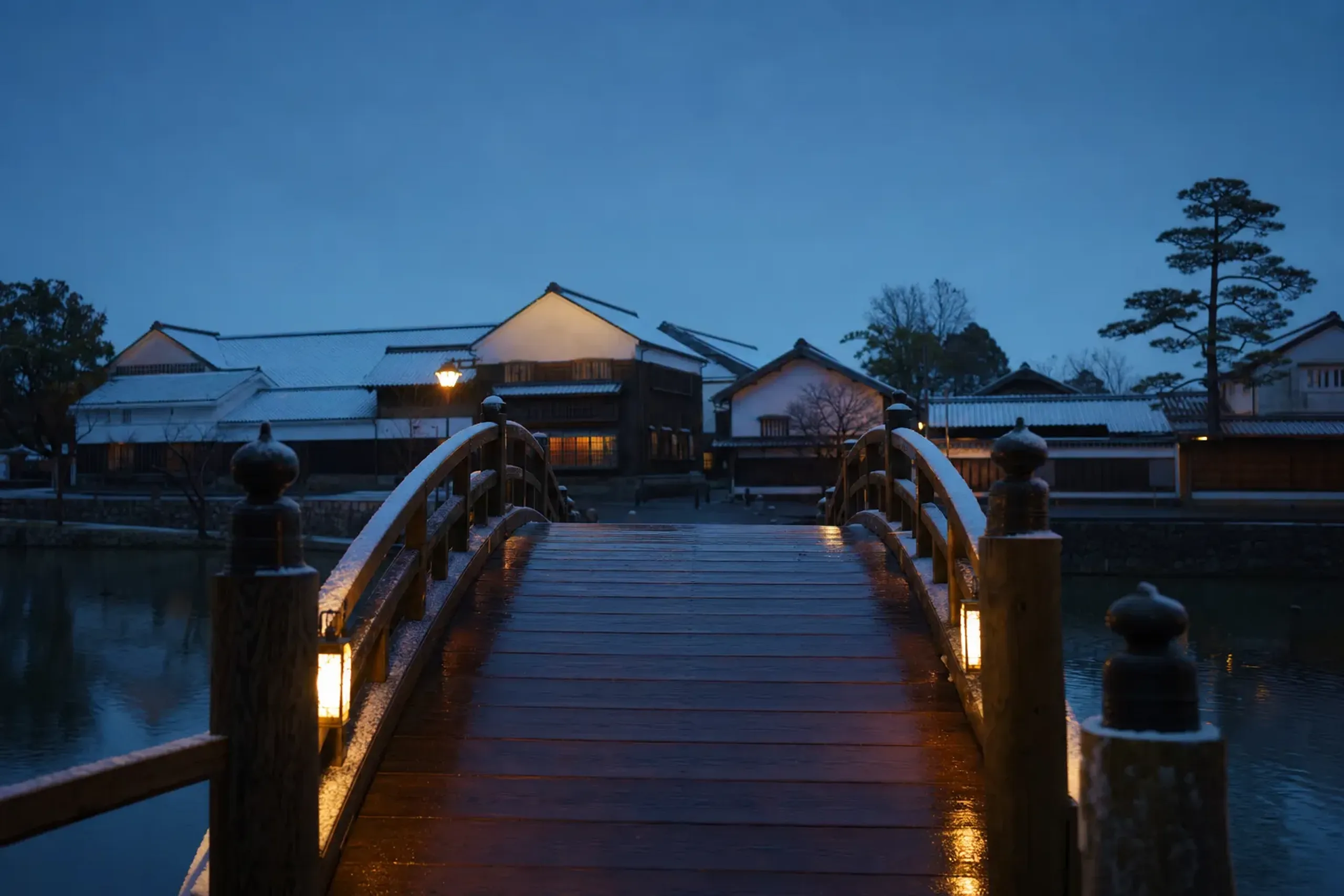 The Omotemon Bridge entrance to Dejima lit at dusk in Nagasaki