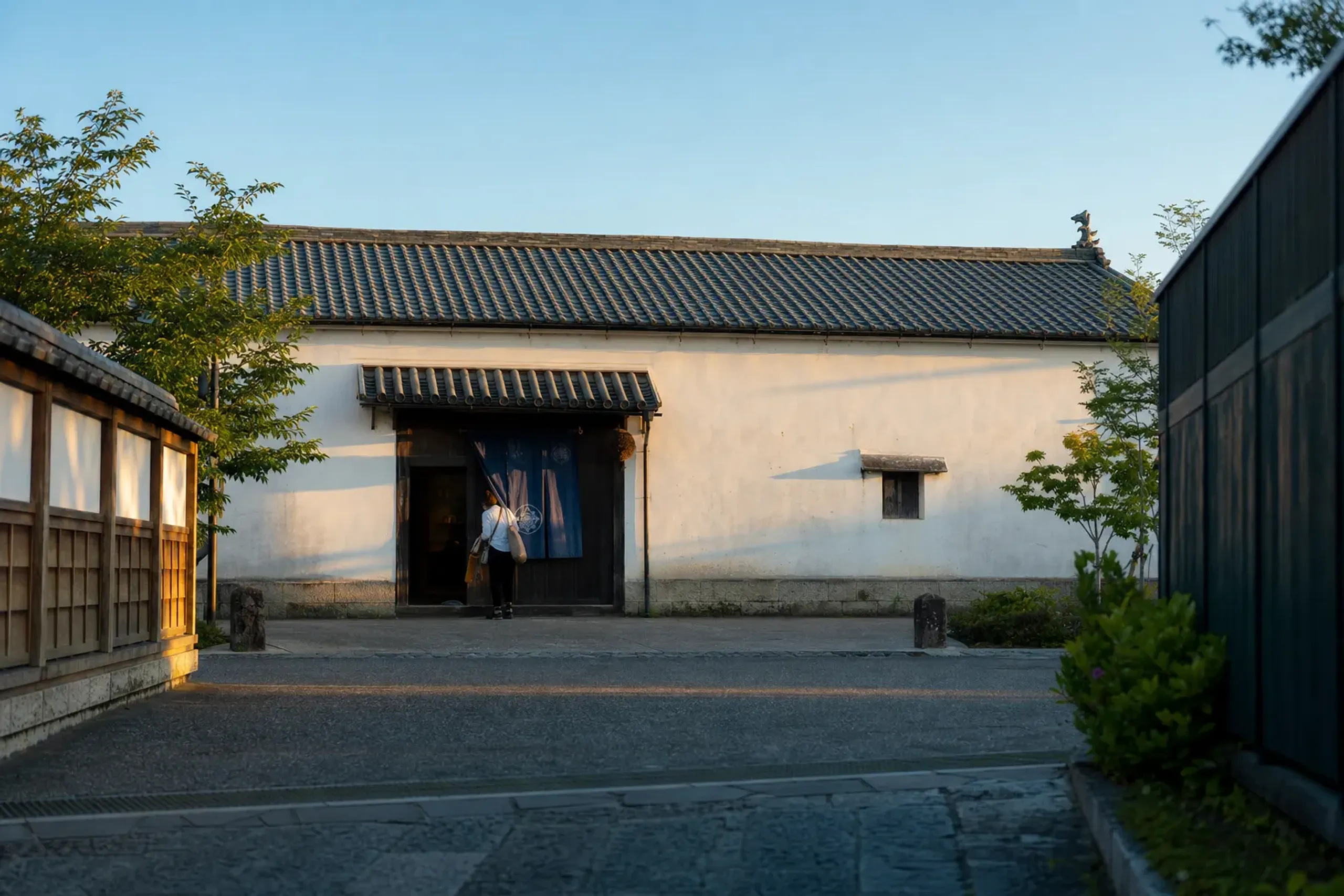 the restored 1872 sake warehouse in Saijo reopened as a museum shop in 2019, with its tiled roof and white plaster facade