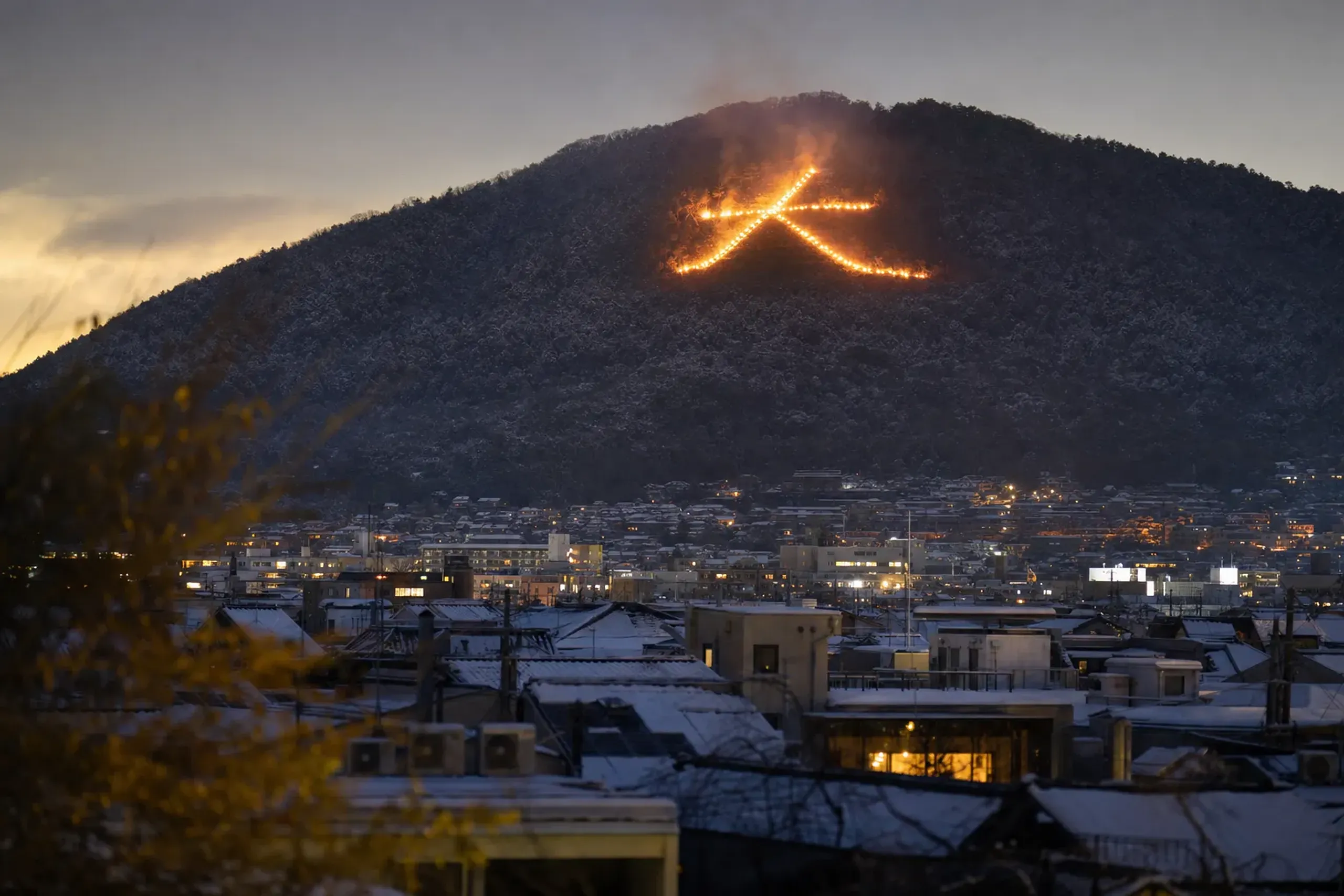 the Daimonji bonfire forming the giant kanji character '大' blazing on the dark mountainside above Kyoto at night