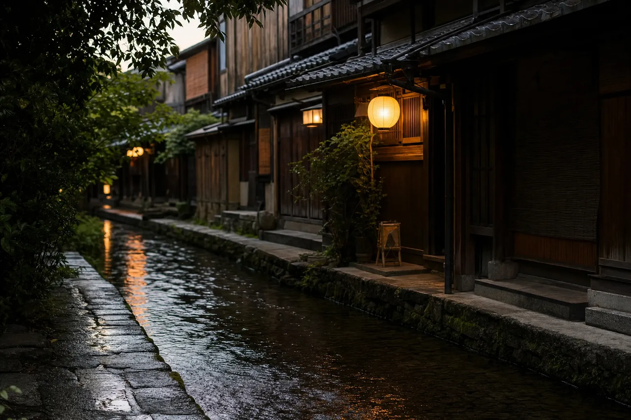 a stone-paved canal lined with old wooden merchant houses and flowing clear water in Gujō Hachiman