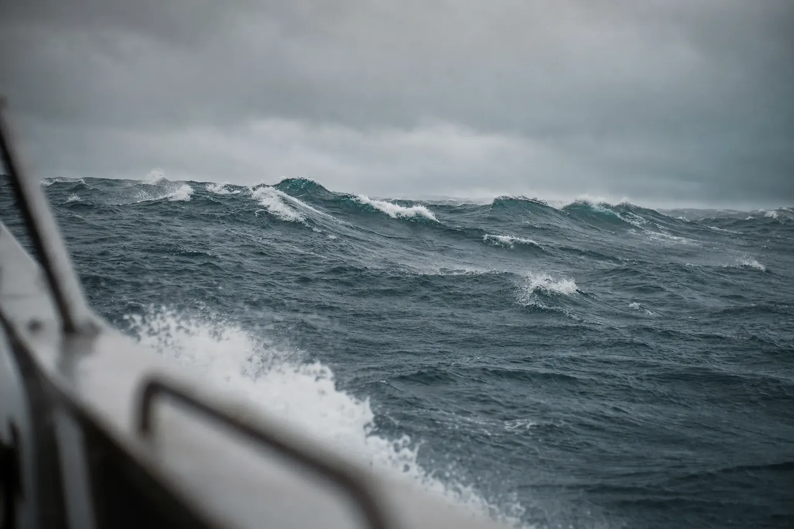 rough winter swells and wind-whipped whitecaps churning across the Kerama sea under a grey February sky