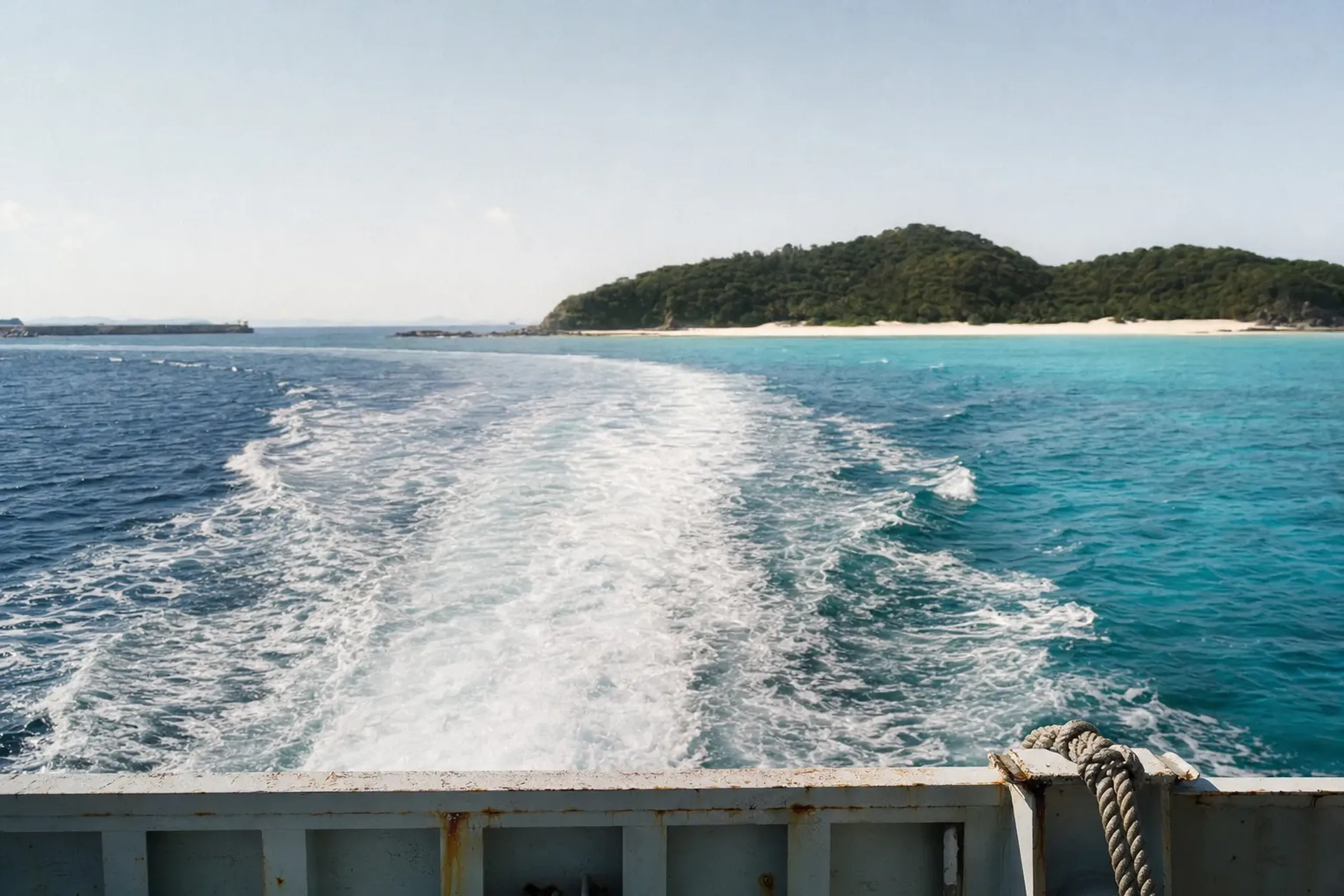 the clear turquoise waters and white-sand beaches of the Kerama Islands seen from a small ferry crossing from Okinawa's main island
