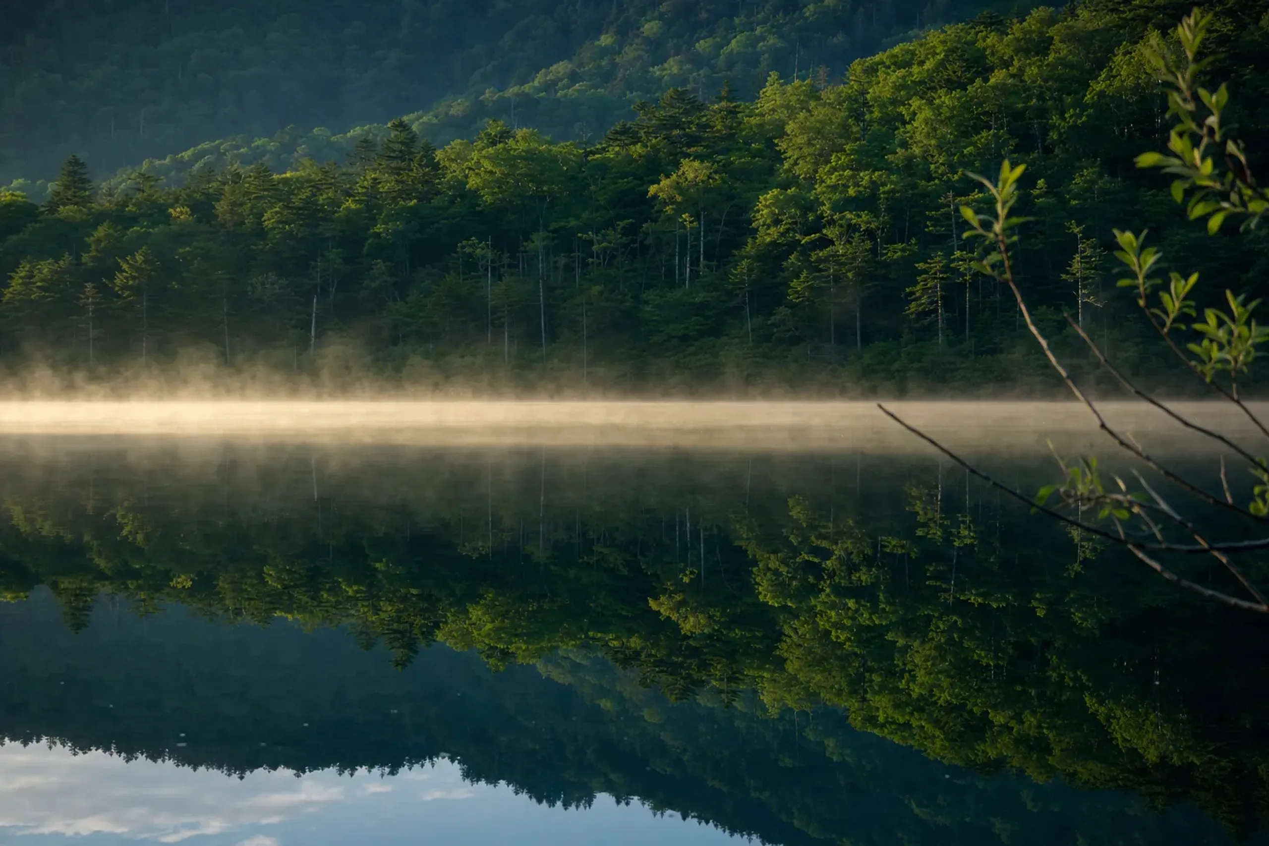 The quiet sheet of Lake Yunoko at 1,478 metres surrounded by highland forest near Yumoto