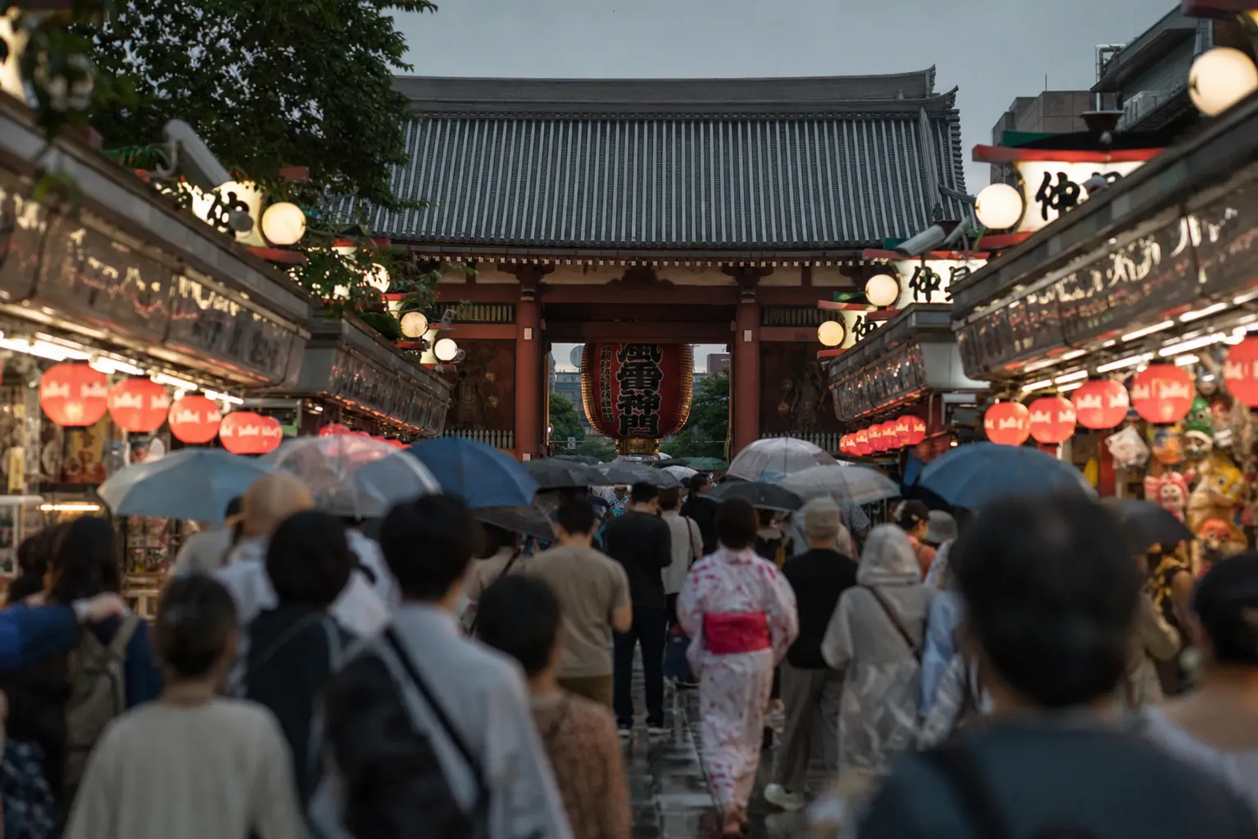 The lantern-lined Nakamise shopping street leading toward the Kaminarimon gate of Sensō-ji, dense with evening crowds