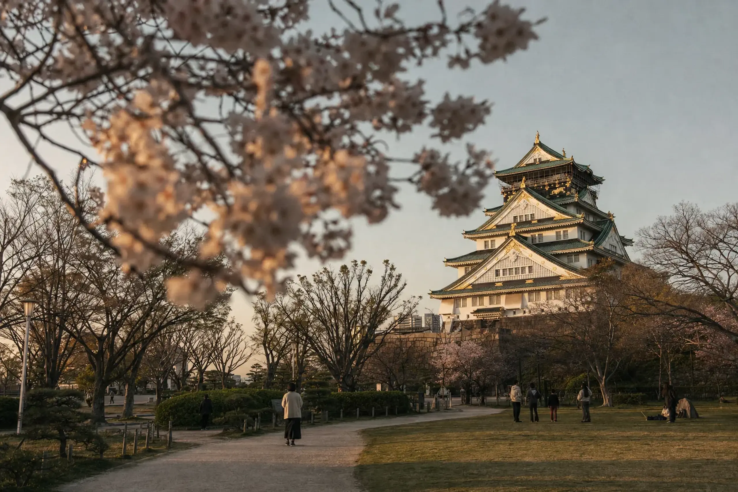 Cherry blossoms in Nishinomaru Garden framing Osaka Castle keep behind the paid gate