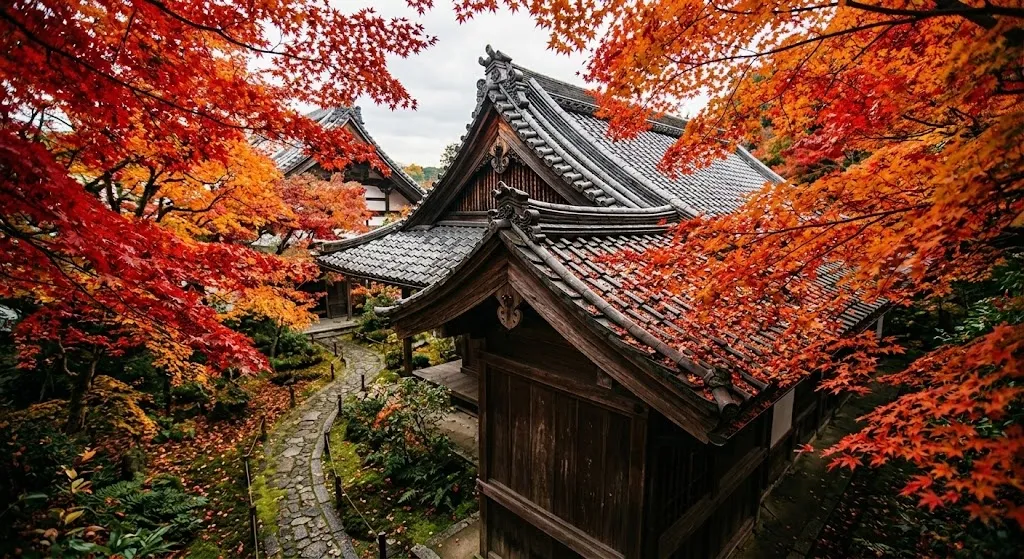 Vibrant red and orange autumn maple leaves framing a traditional Japanese temple roof.