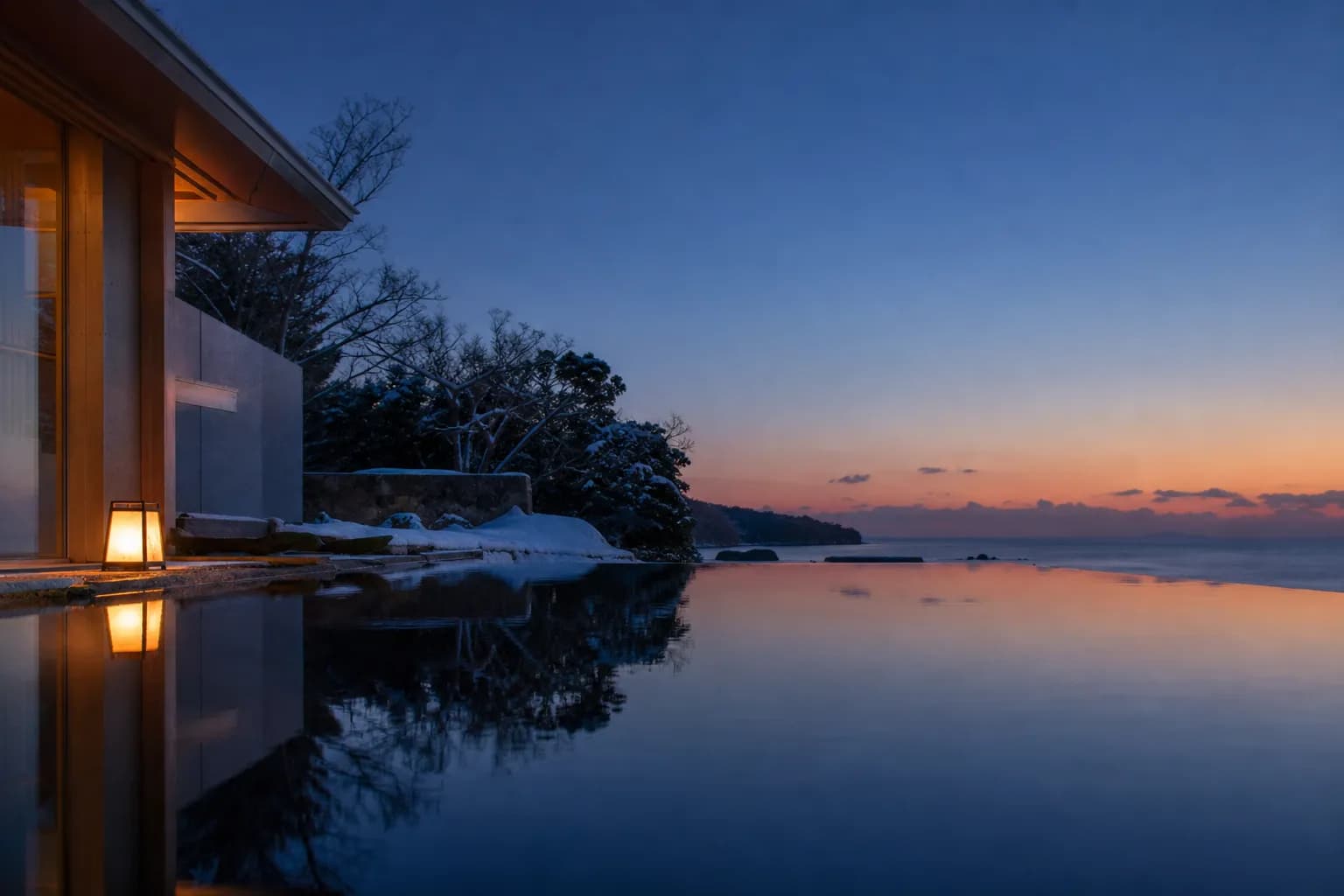 Private villa with infinity pool facing the ocean in Okinawa at dusk