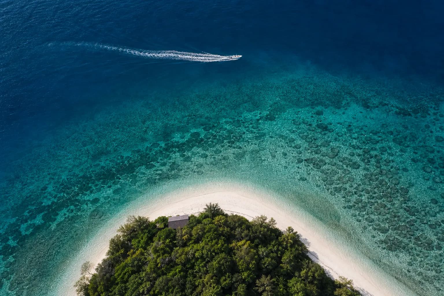 Aerial view of clear blue Kerama island waters with visible coral reef in Okinawa