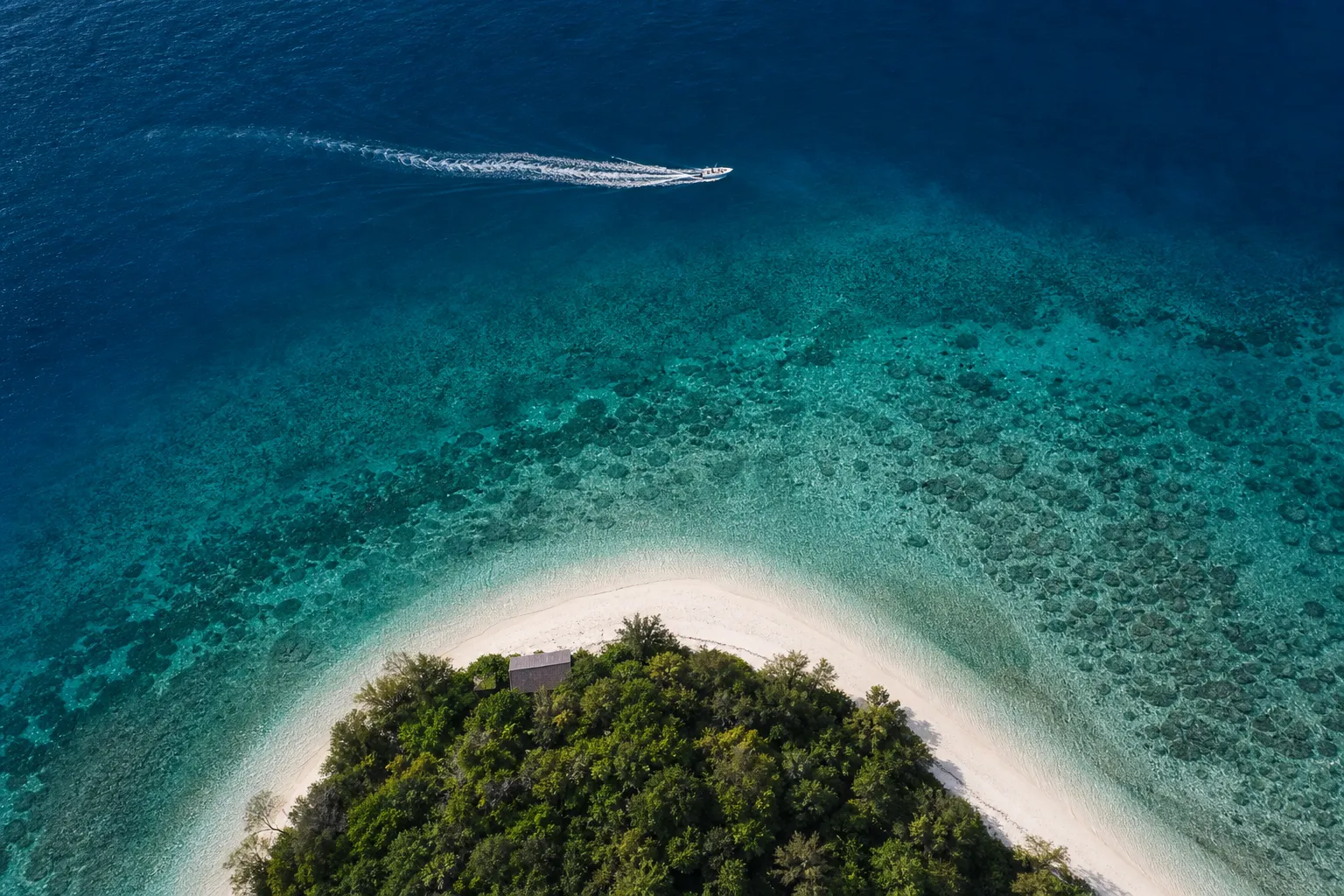 Aerial view of clear blue Kerama island waters with visible coral reef in Okinawa