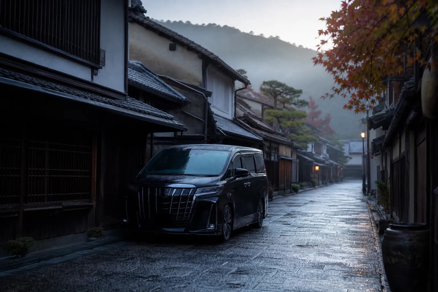Black chauffeured minivan on a quiet Kyoto street near traditional townhouses