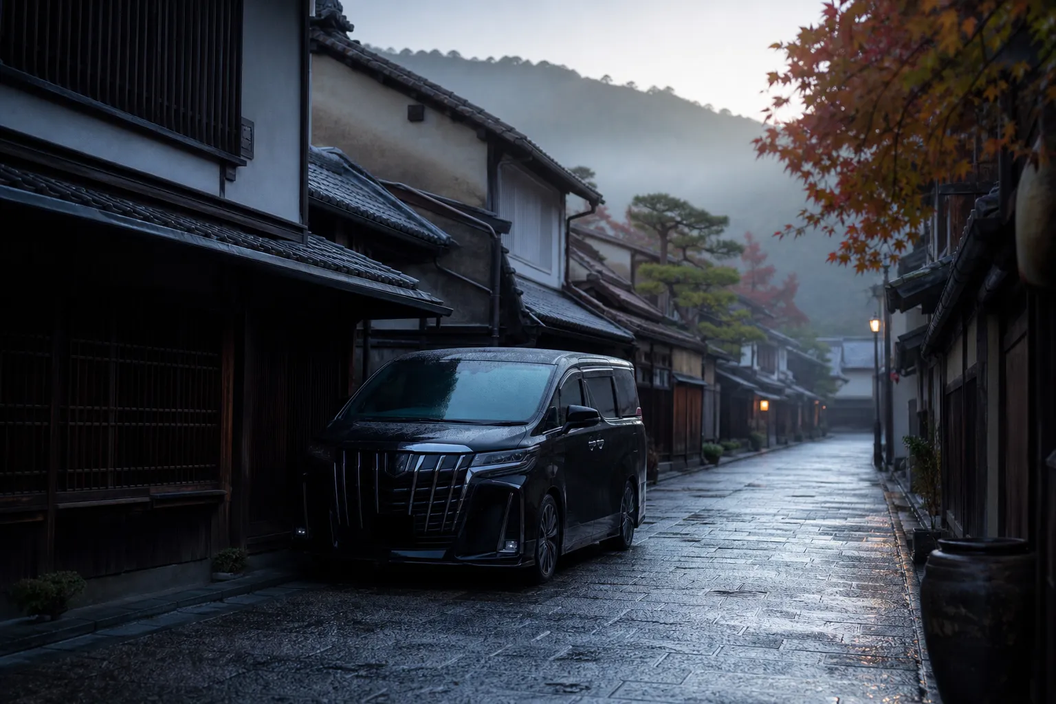 Black chauffeured minivan on a quiet Kyoto street near traditional townhouses