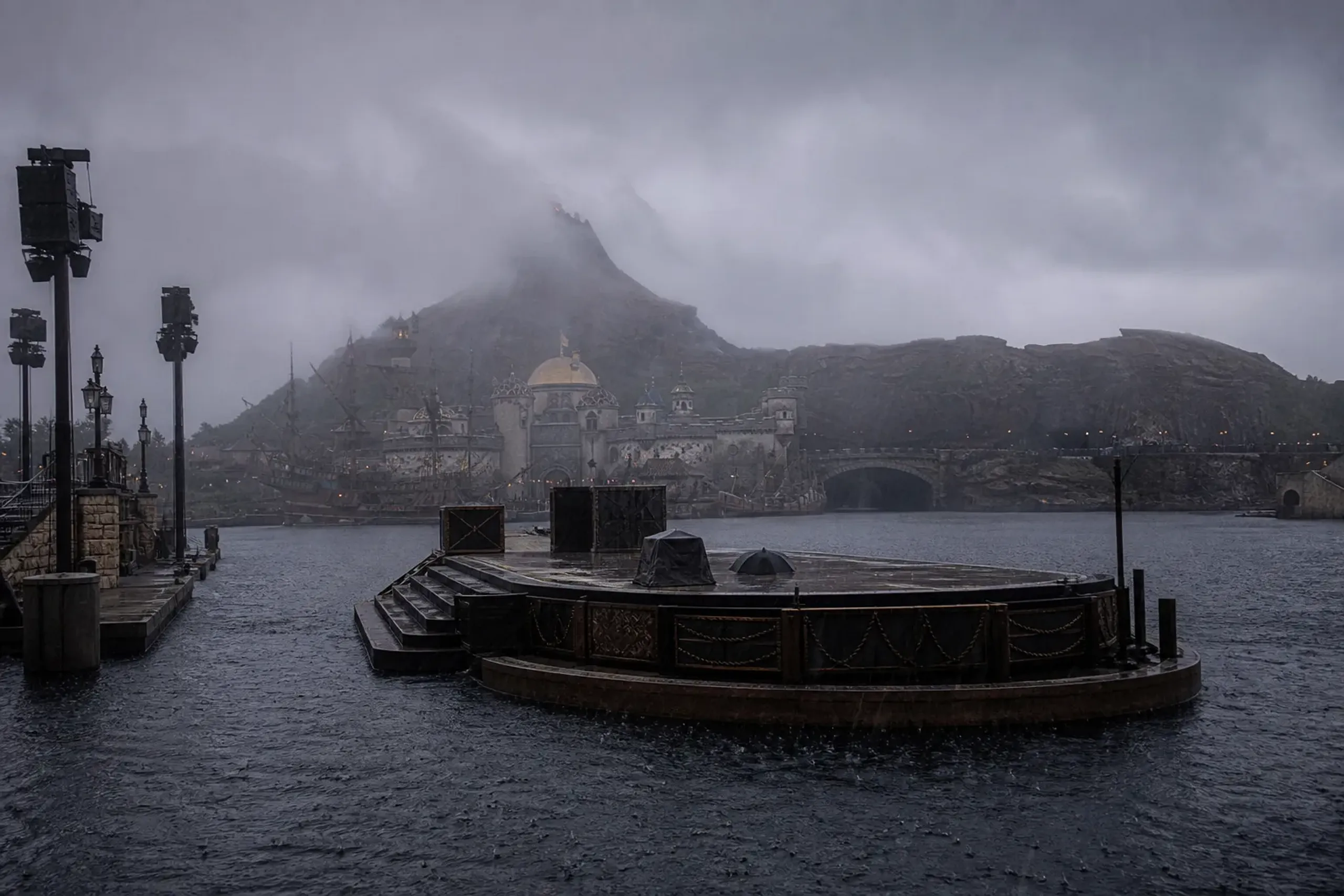 the harbor stage and water of Mediterranean Harbor at Tokyo DisneySea empty in windy rain, with the Prometheus volcano in the background
