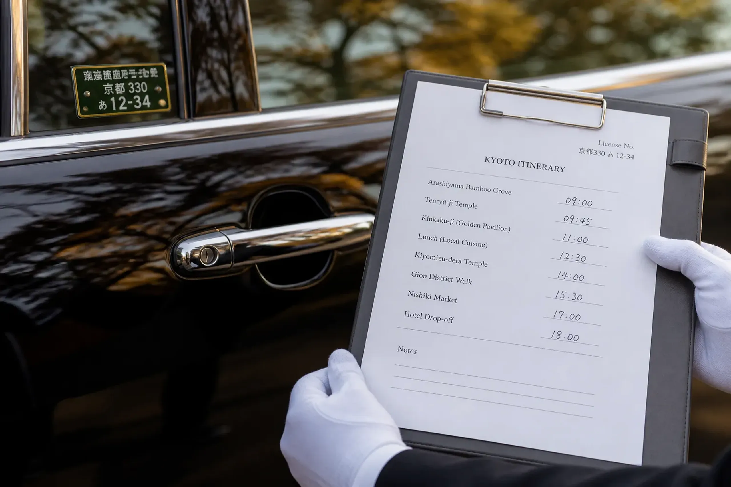Chauffeur holding itinerary notes next to a licensed passenger vehicle in Kyoto
