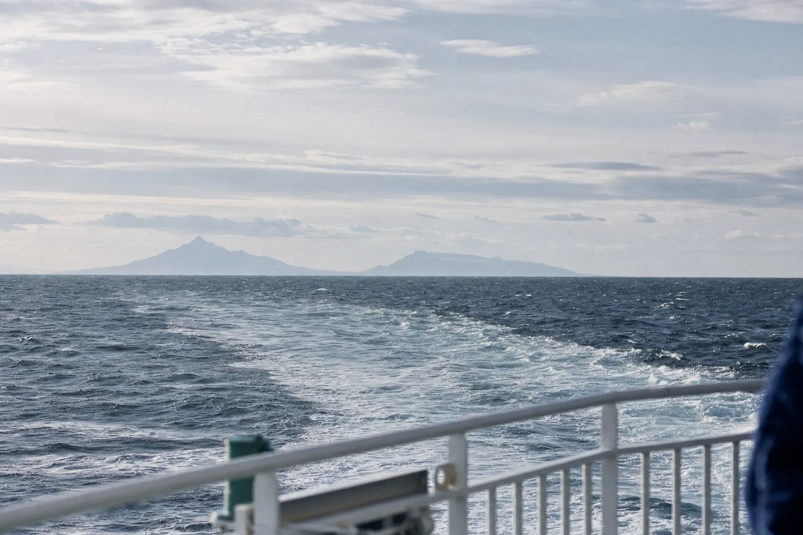 A Heartland Ferry vessel crossing the volatile Sea of Japan from Wakkanai port toward the twin silhouettes of Rishiri and Rebun