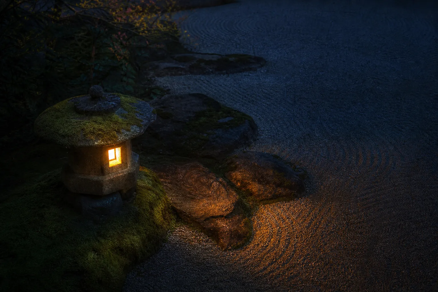 A serene, moss-covered traditional Japanese stone garden at twilight