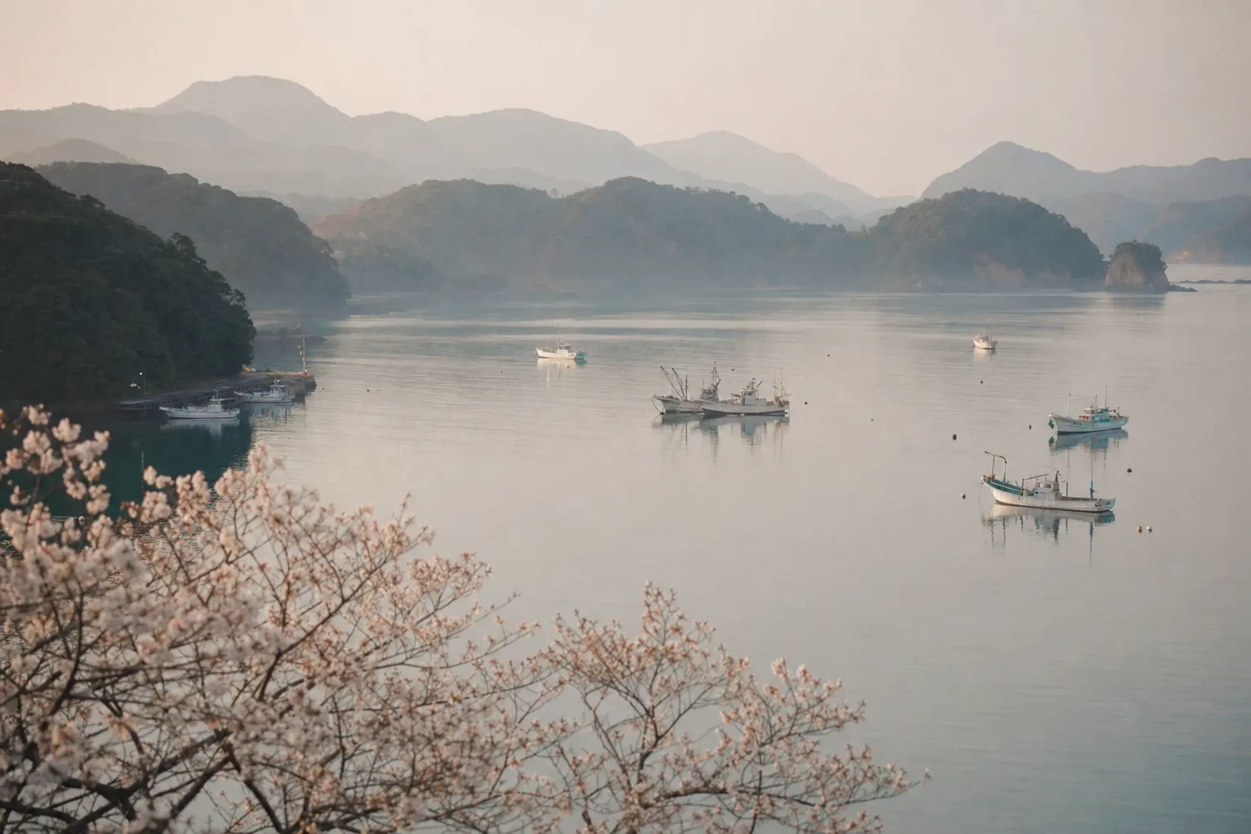 Misty morning view of Shimoda Bay with boats and surrounding hills in Shizuoka