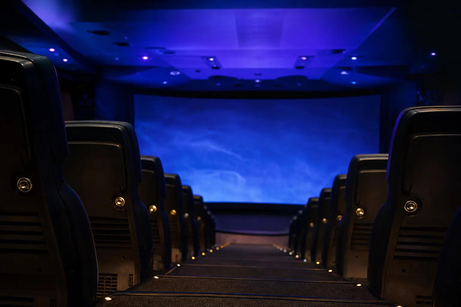 Dark 4-D theater at Universal Studios Japan with seats facing a large screen under blue stage lighting