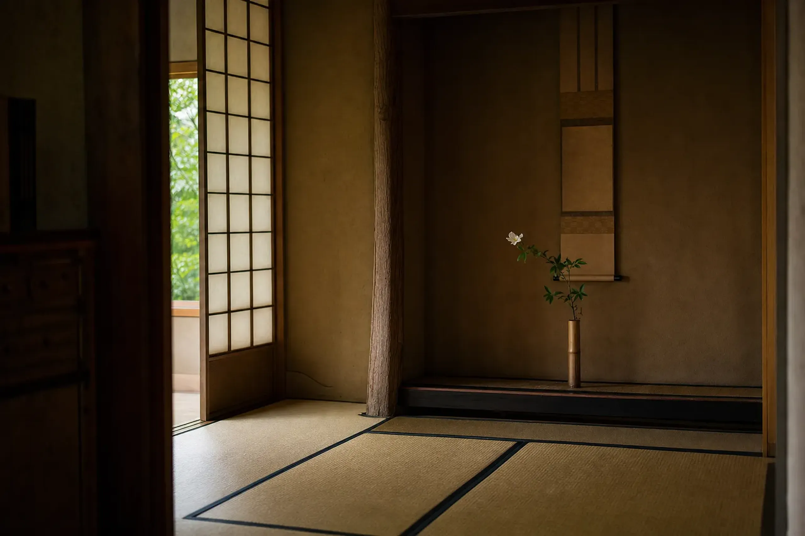 a composed tatami room at Sumiya with a single hanging scroll and seasonal flower in an alcove, empty and softly lit