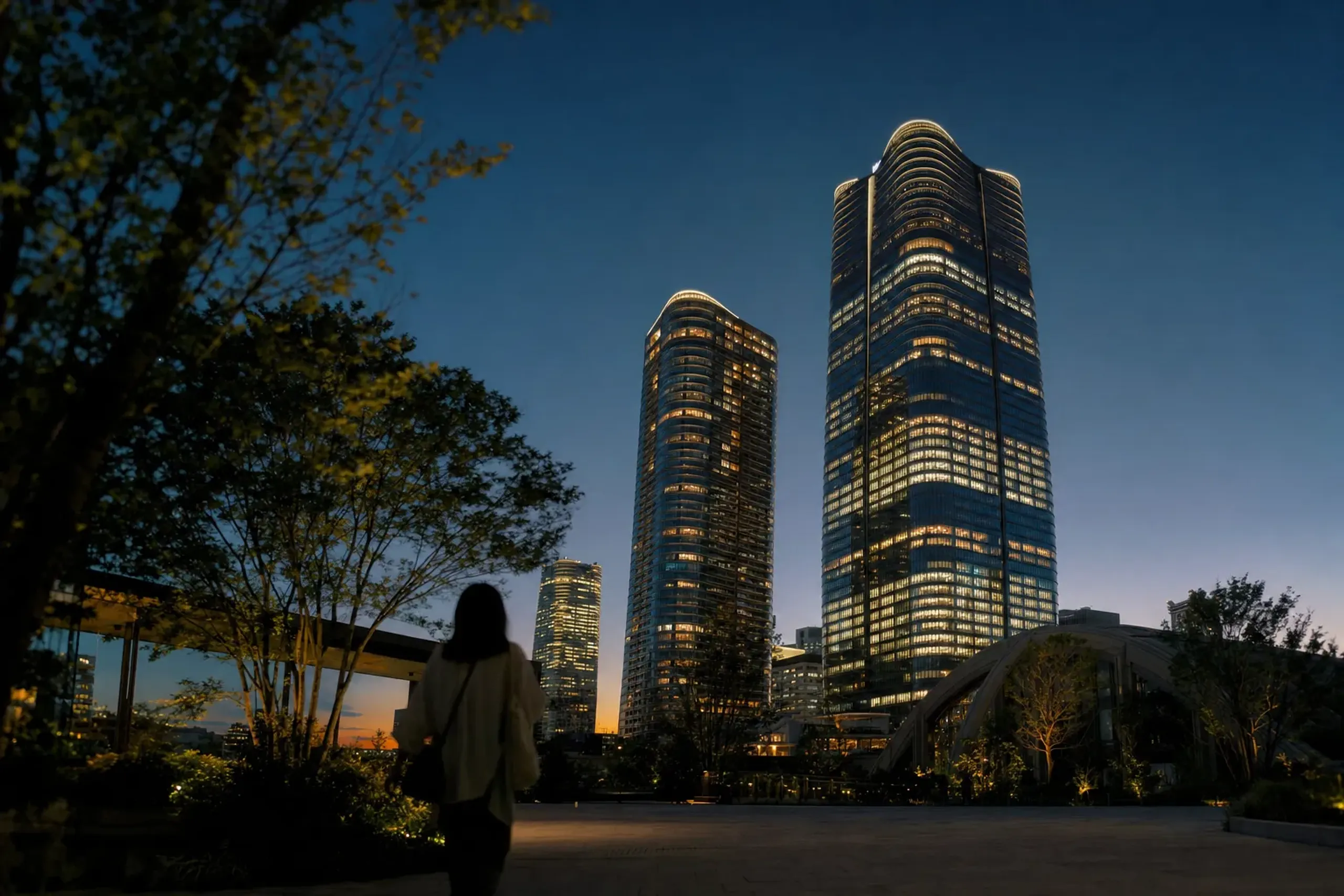 The Azabudai Hills complex in Minato, Tokyo, its modern towers illuminated at dusk