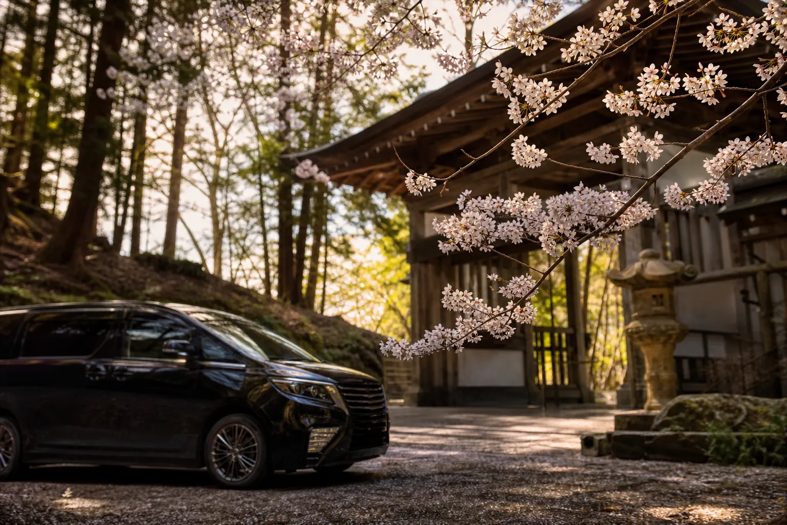 Luxury chauffeured minivan at a Koyasan temple gate among cedar trees