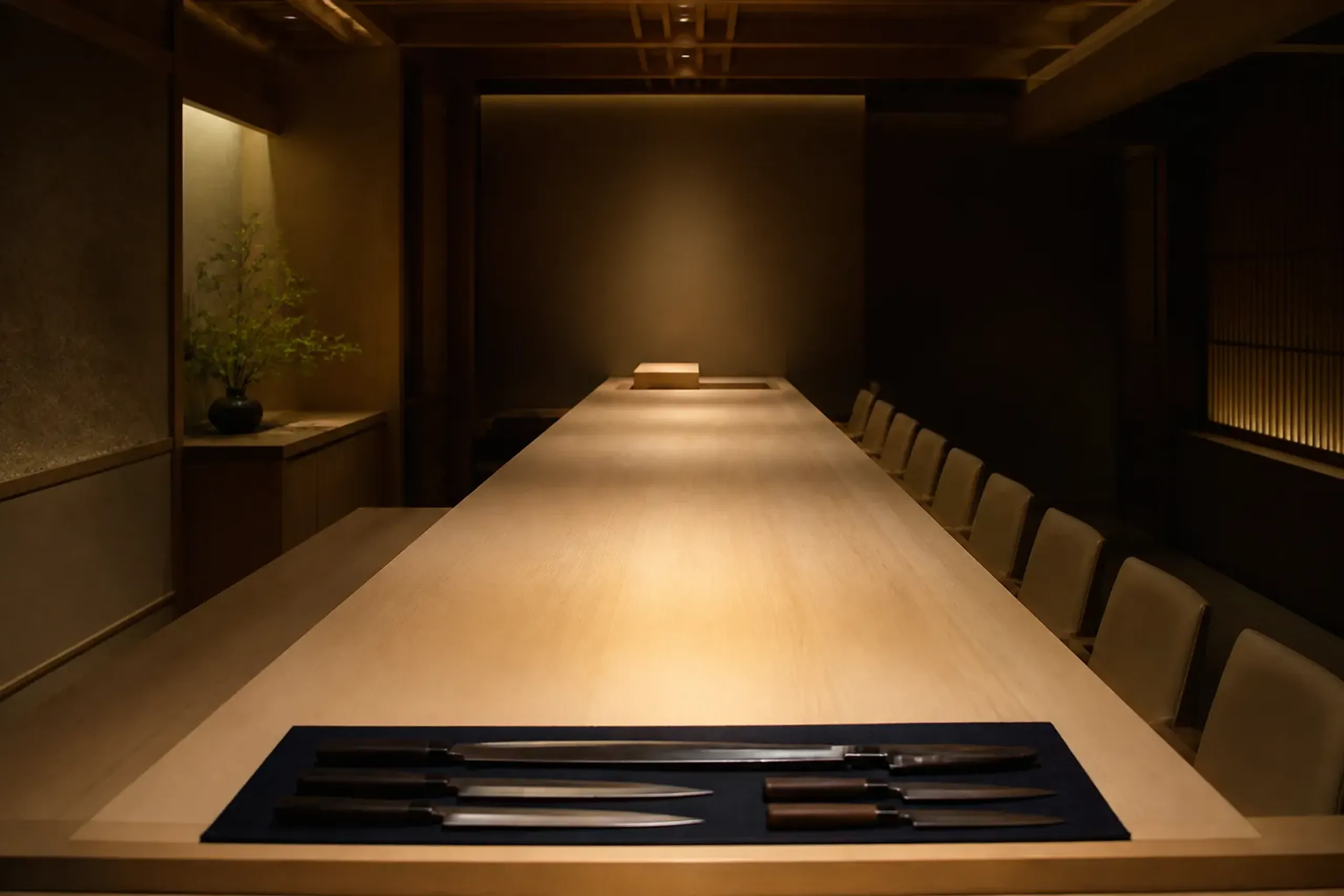 Empty high-end Japanese sushi counter in pale wood with soft lighting before service