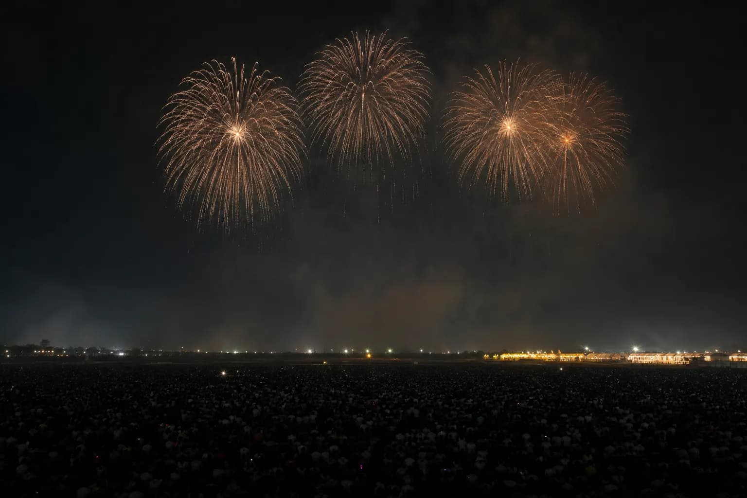 Large-scale fireworks display above a stadium-like venue at night