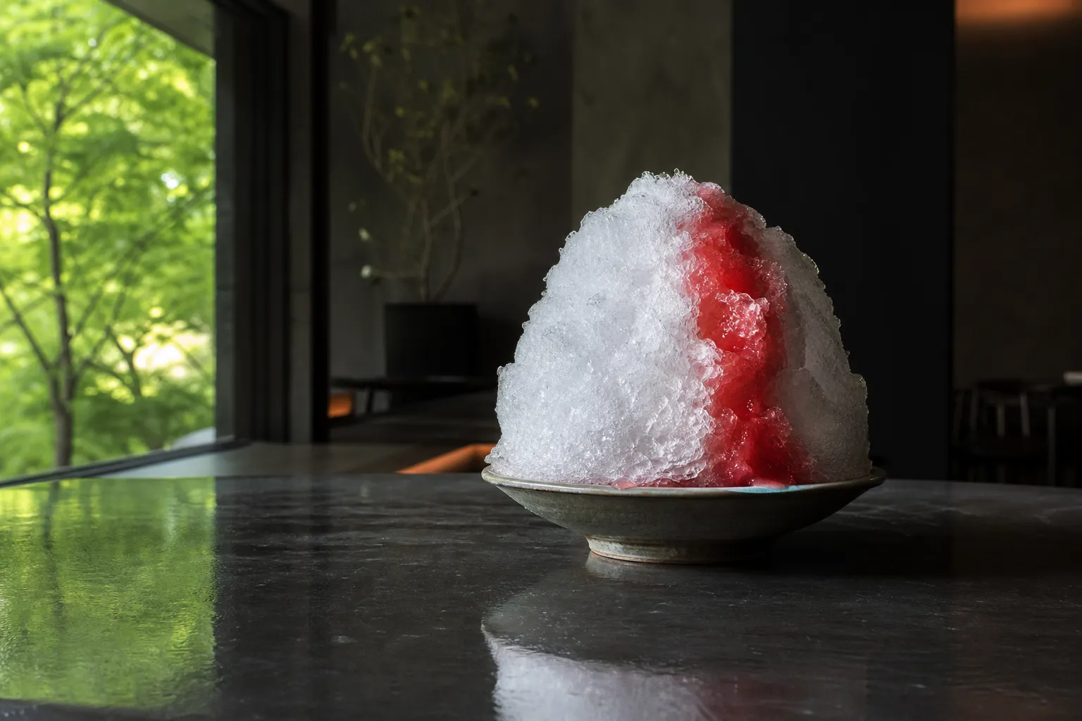 the Tottori watermelon kakigori of Hotel New Otani Tokyo, a mound of snow-fine Nikko natural ice crowned with vivid red watermelon syrup, served on a polished table in the air-conditioned calm of KATO