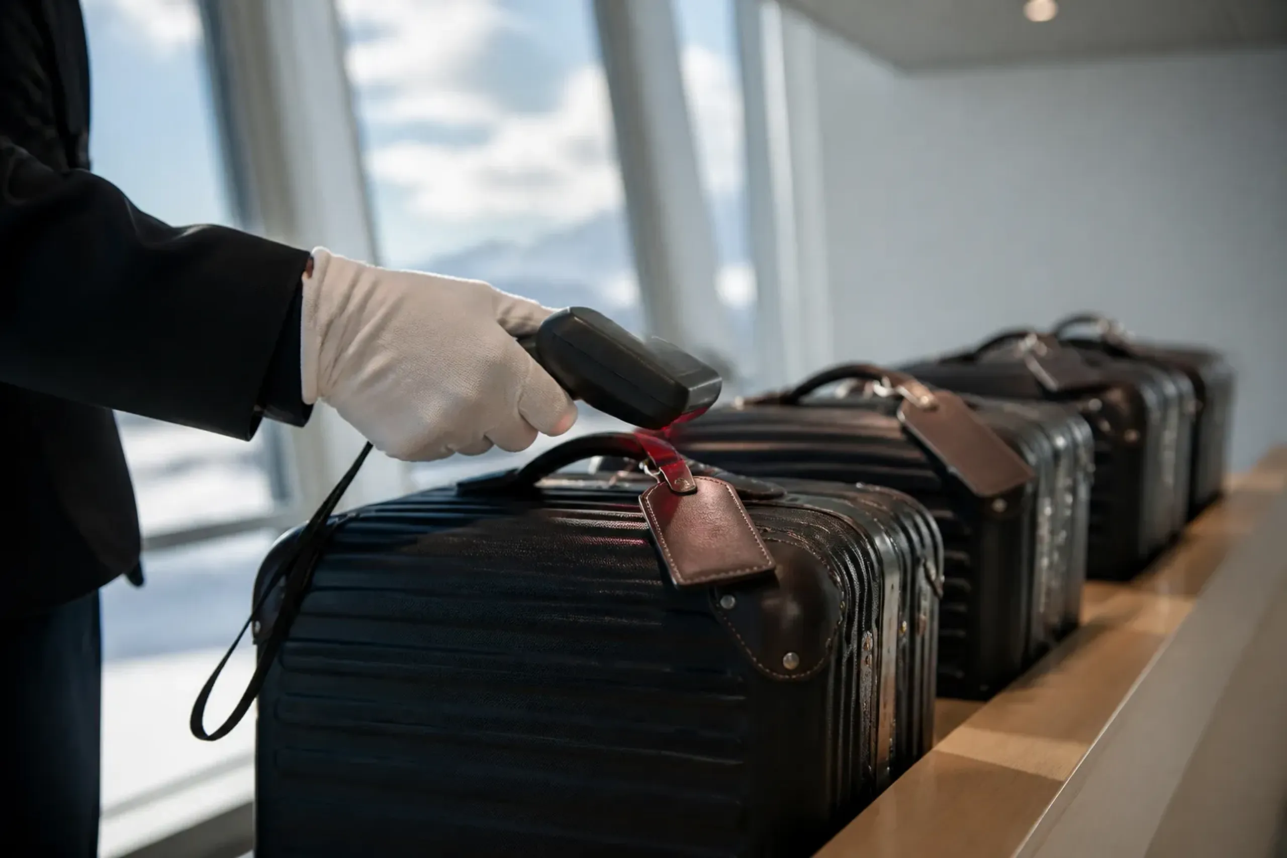 Premium suitcases at an airport luggage forwarding counter in Japan with staff assisting