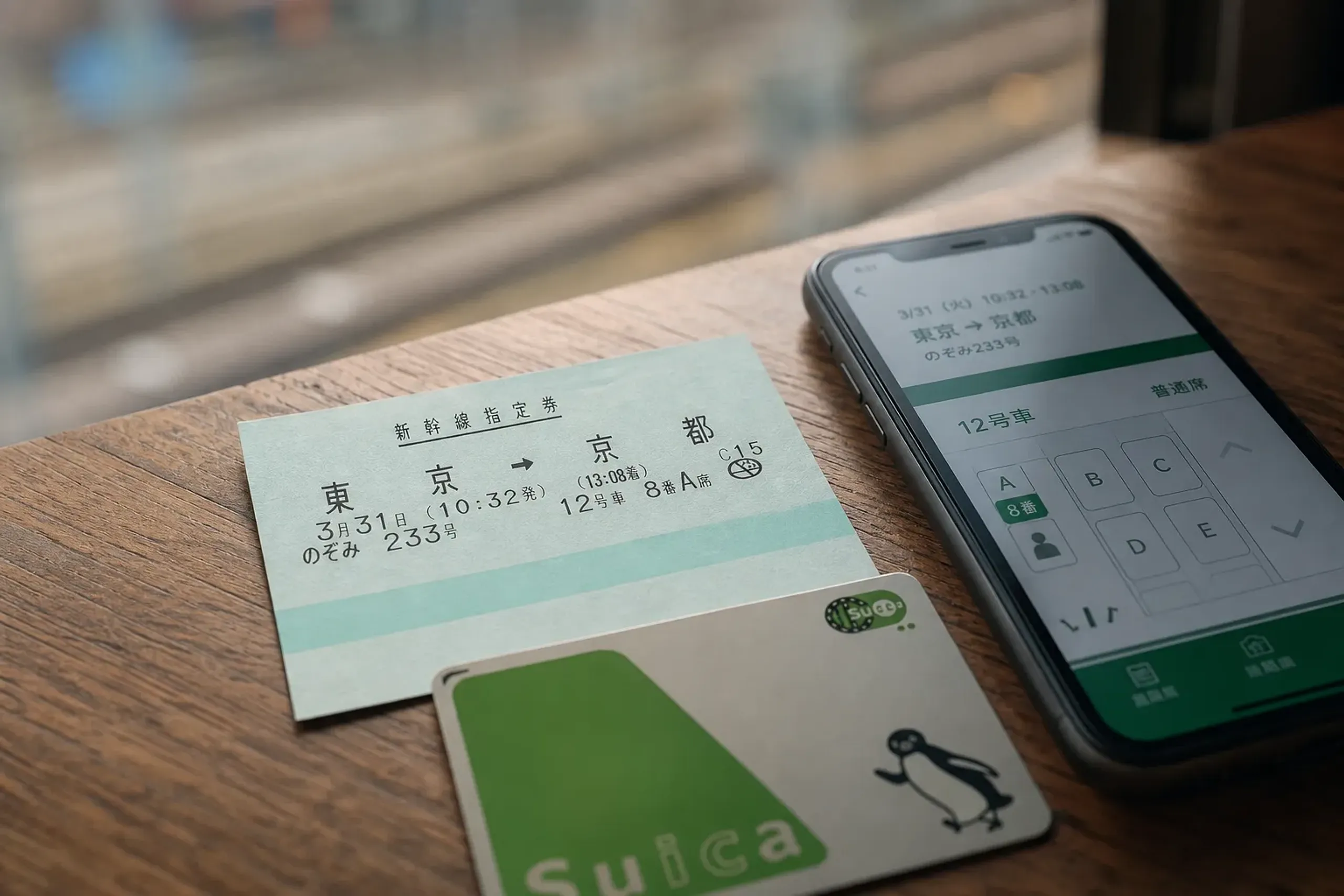 Smartphone showing Shinkansen reservation next to a Suica card