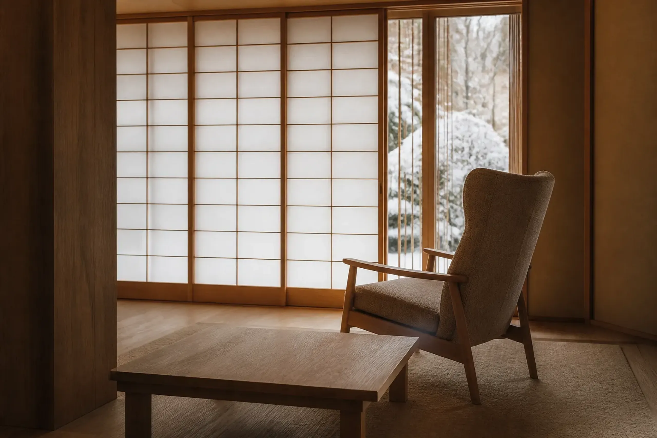 Empty hotel lounge corner with high-back chair and shoji screen creating visual privacy