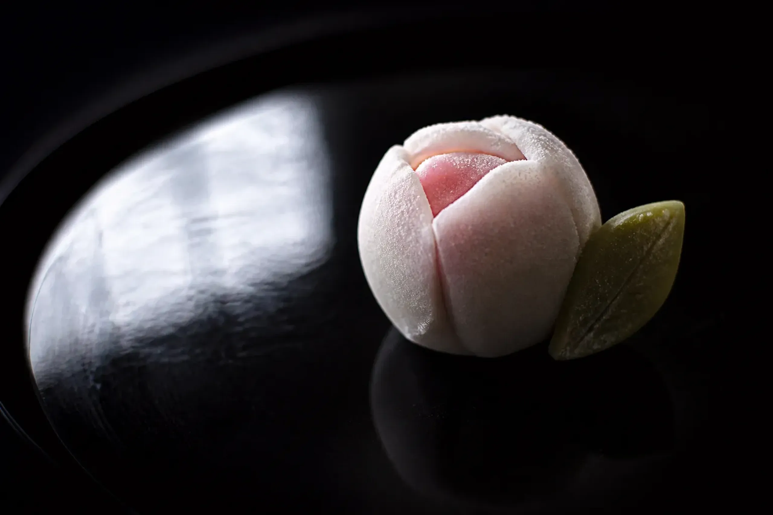 a seasonal namagashi wagashi confection shaped as a wintering-over motif resting on a lacquer plate, as documented by the Agency for Cultural Affairs