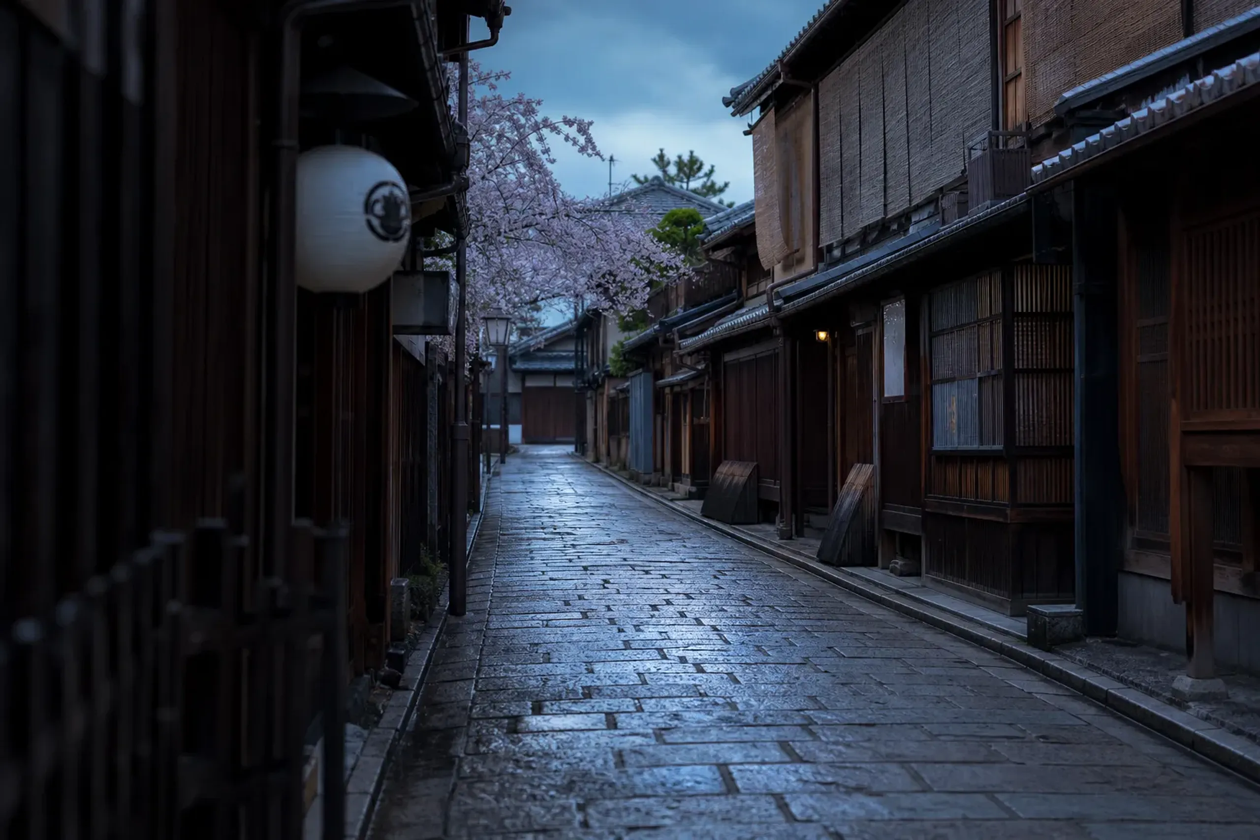 Empty Kyoto lane at dawn with machiya townhouses and a paper lantern