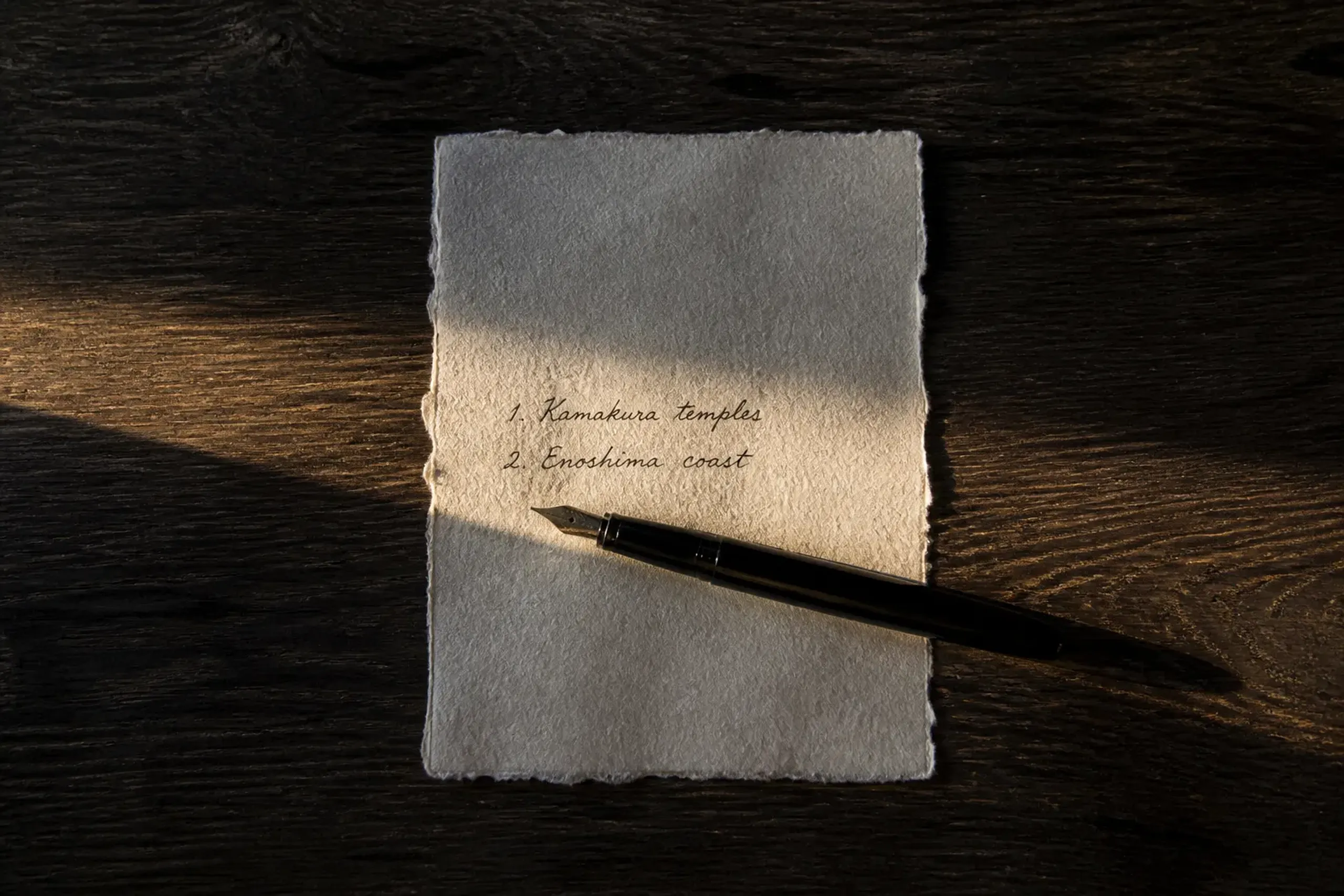 Paper itinerary and pen arranged on a wooden table