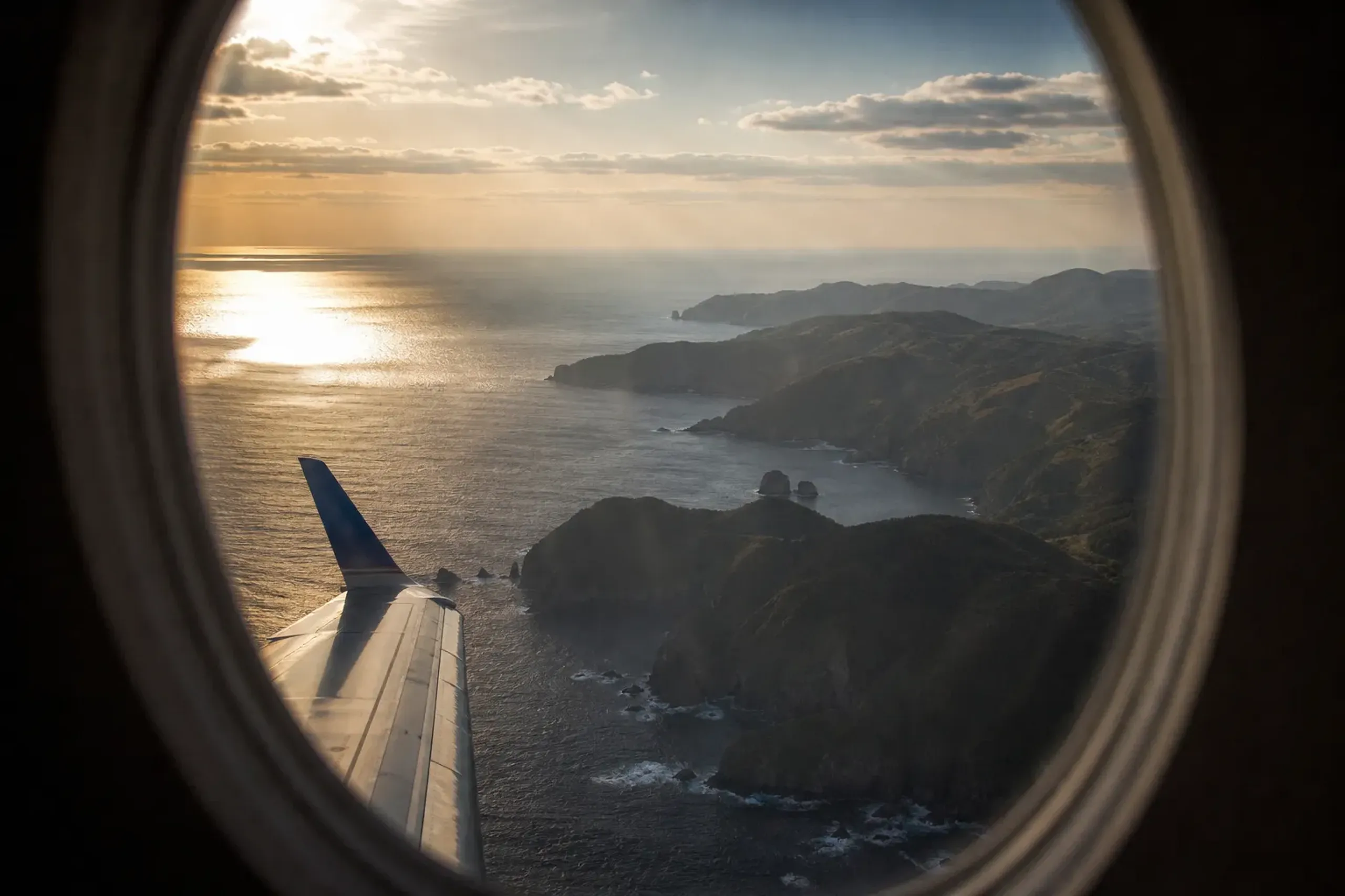 Aerial view of the Oki Islands coastline from an airplane window with cliffs and deep blue water below
