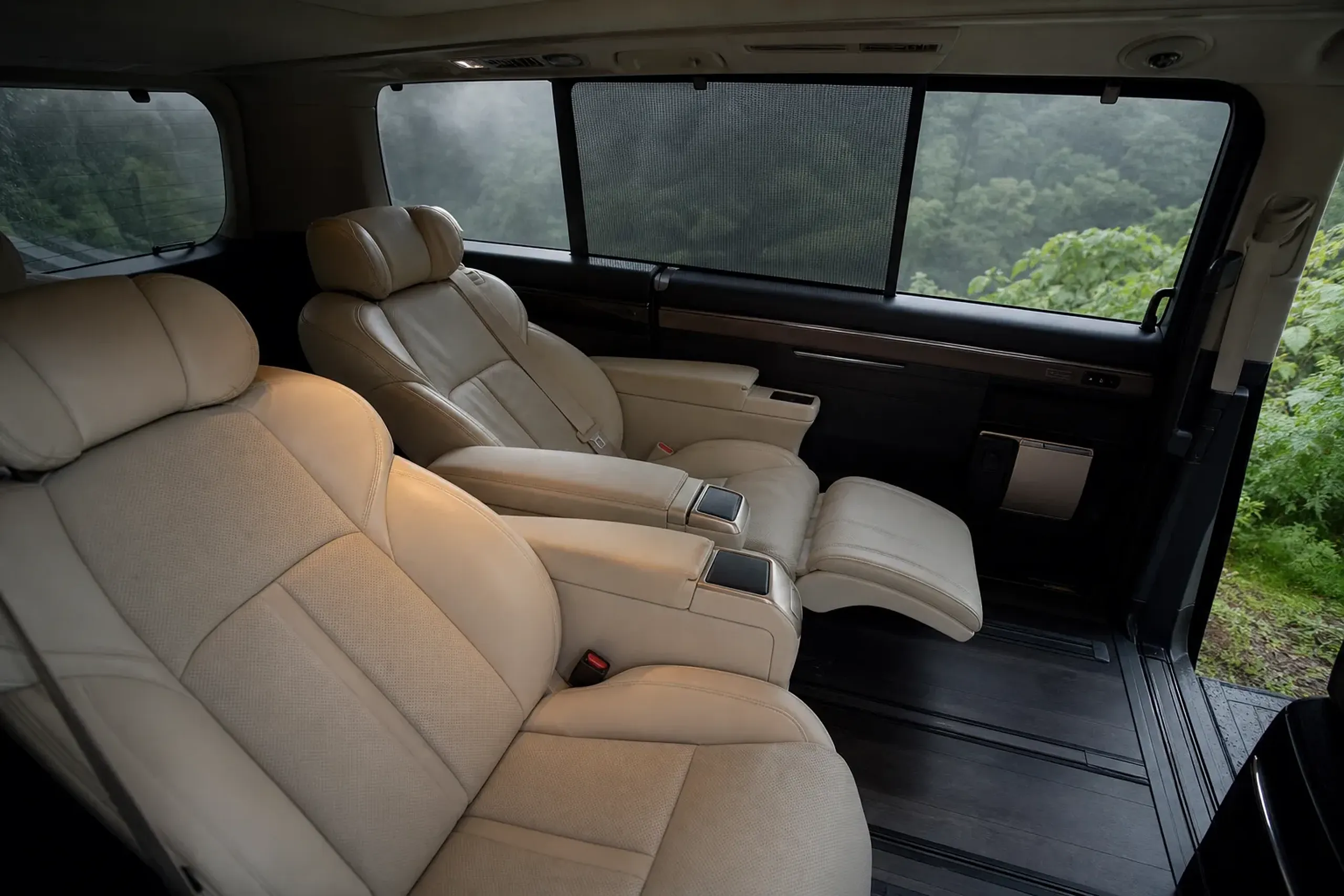 The hushed interior of a Toyota Alphard showing its reclined leather captain's seats and upright cabin