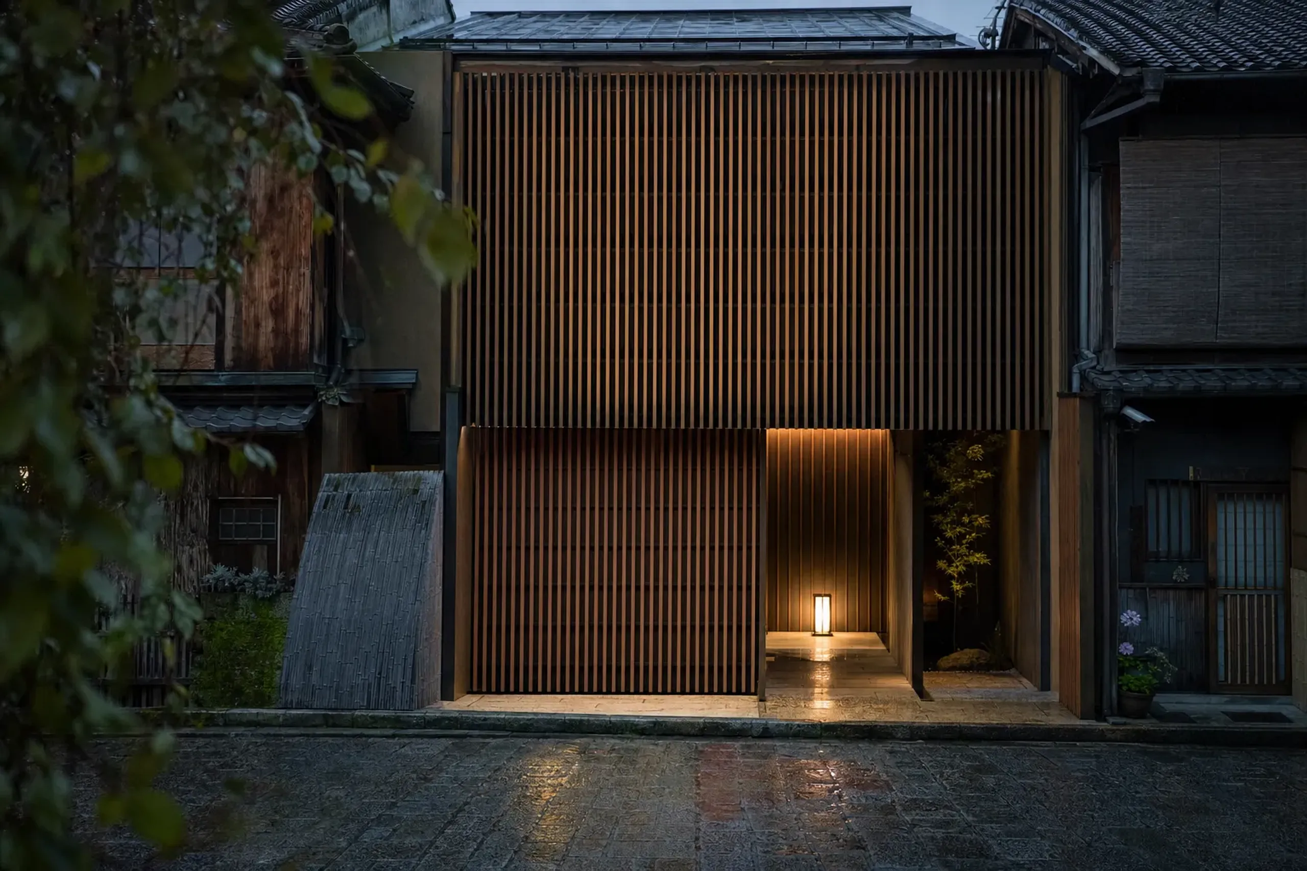 The timber façade of The Shinmonzen hotel along Shinmonzen-dori in Gion, its wooden slats and quiet frontage blending into the historic street